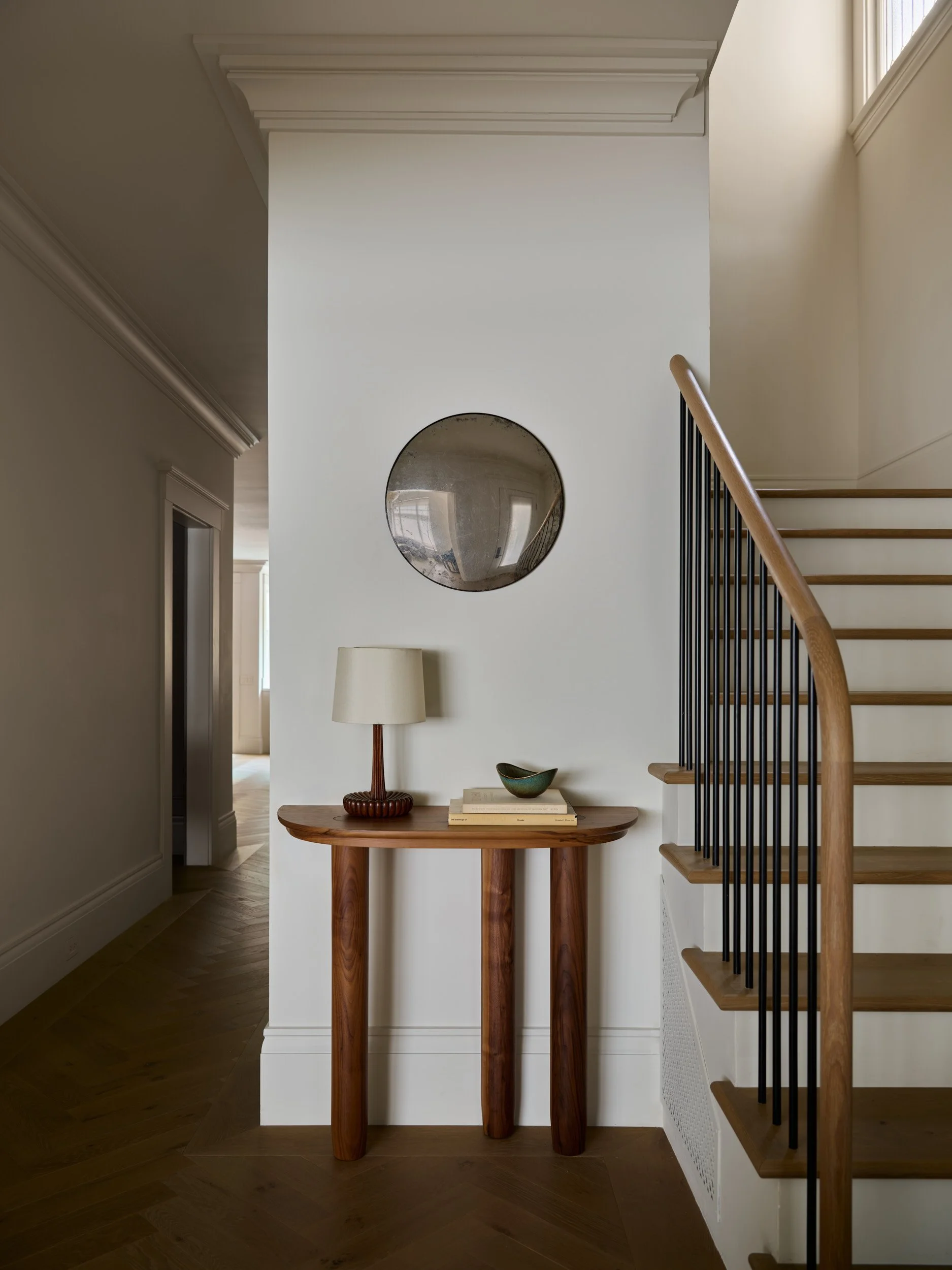 Entryway with side table and decor, staircase.