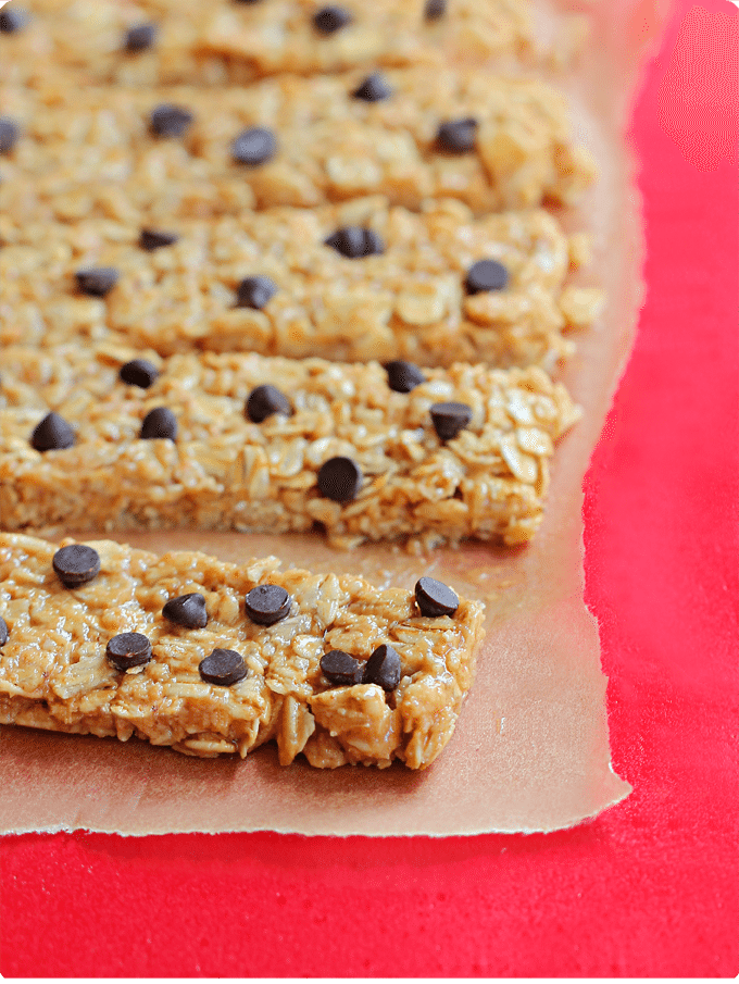 Unbaked granola bars with oats, honey, and chocolate chips on parchment paper.