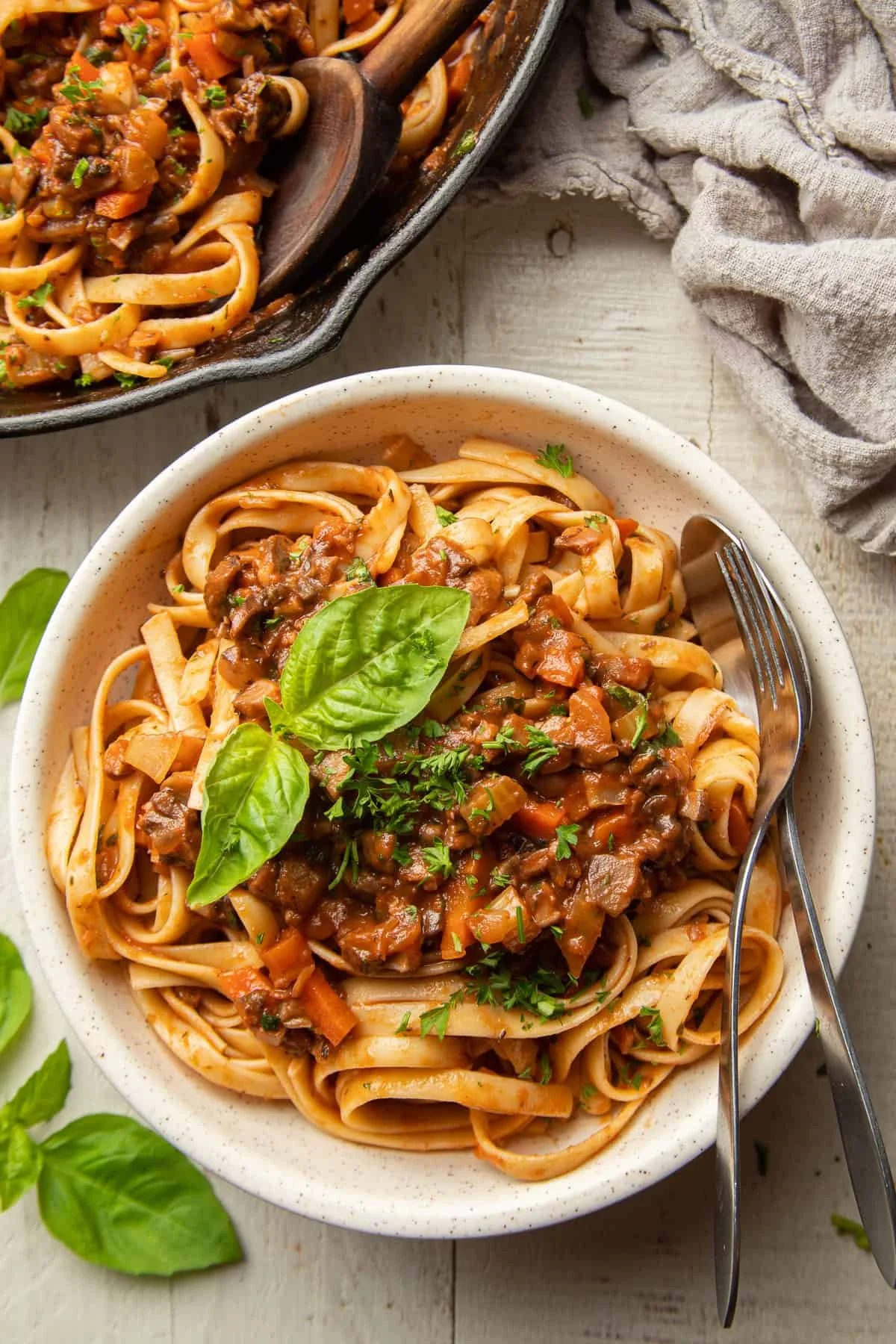 plate of pasta mushroom bolognese garnished with fresh basil