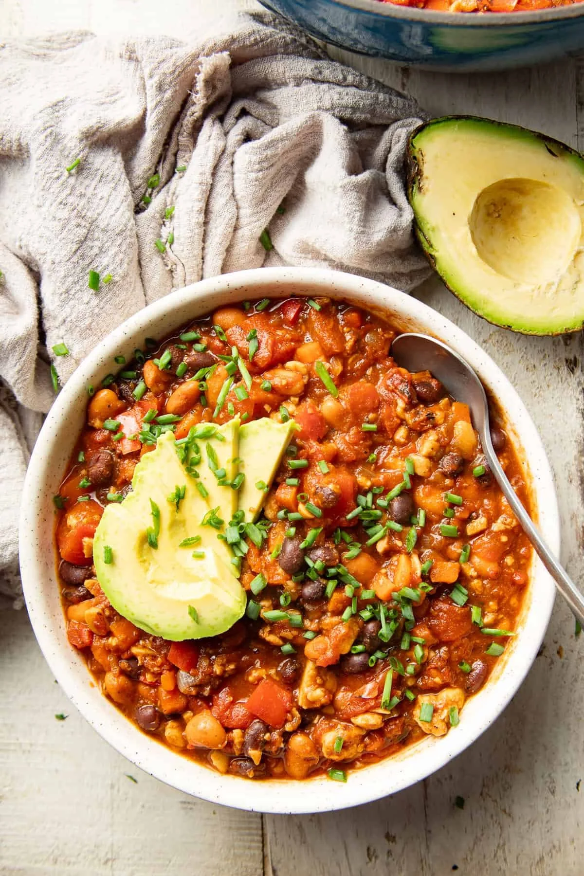 bowl of tempeh chili topped with avocado slices