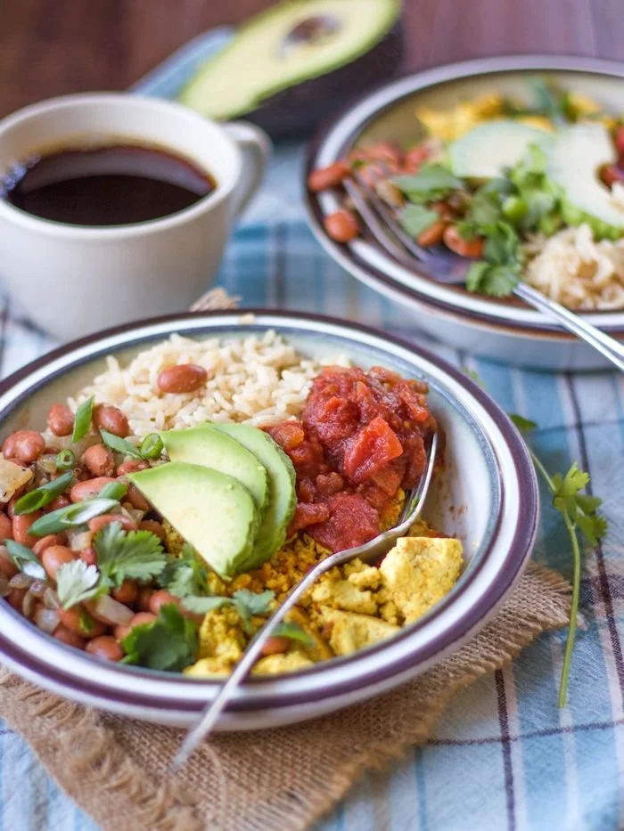 Tofu ranchers topped with avocado and salsa served with pintos and rice
