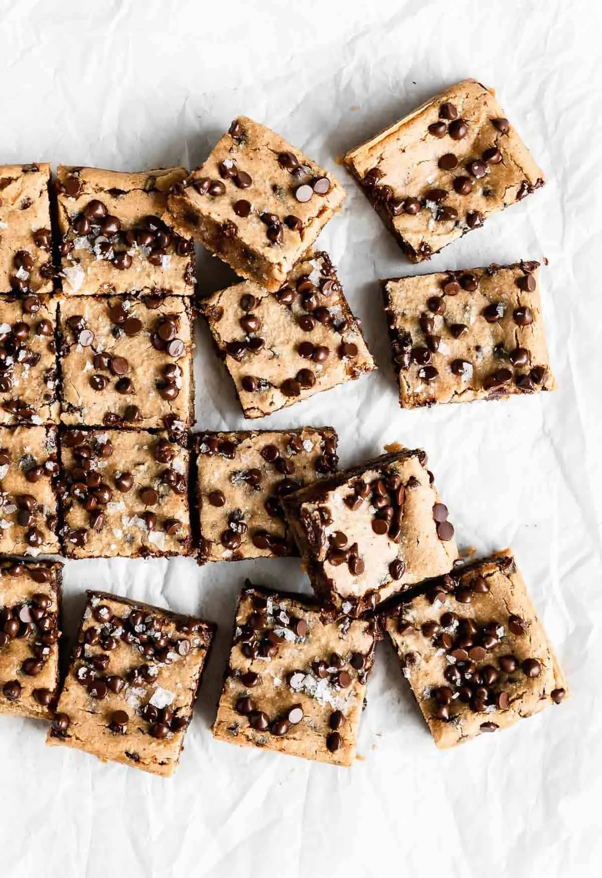 Rectangle and square chocolate chip cookie bars with sea salt on parchment paper