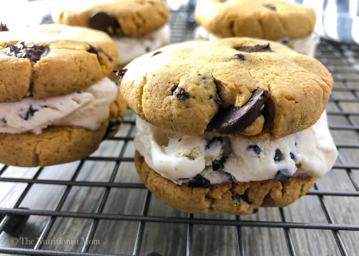 Close-up of a chocolate chip ice cream sandwich made with chocolate chip cookies and vanilla ice cream with chocolate chips.