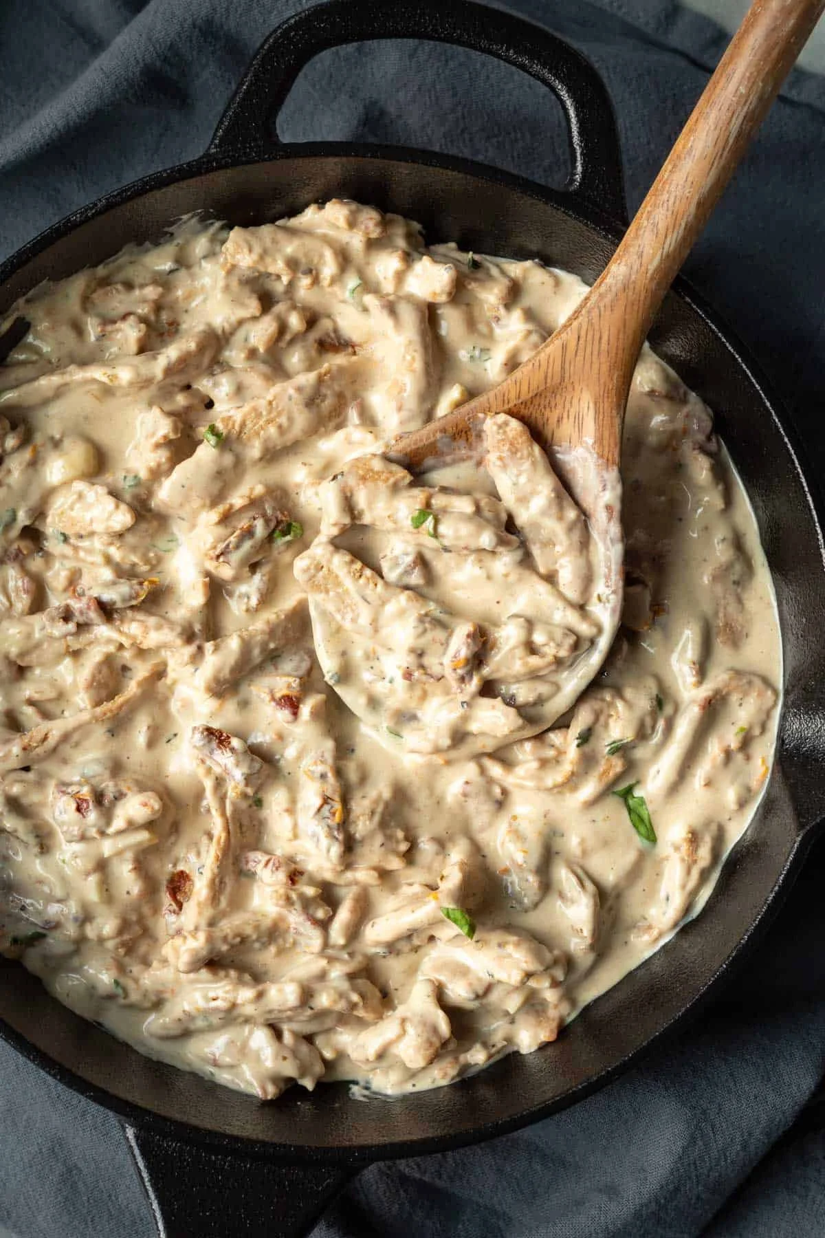 Creamy vegan marry me mushroom stew in a cast iron skillet with a wooden spoon