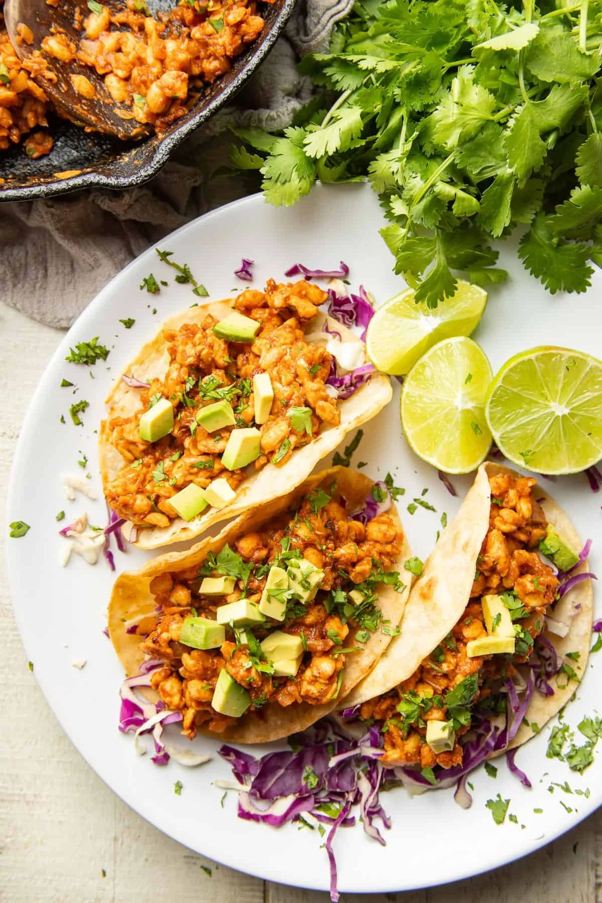 plate of 3 chipotle tempeh tacos with a side of lime wedges