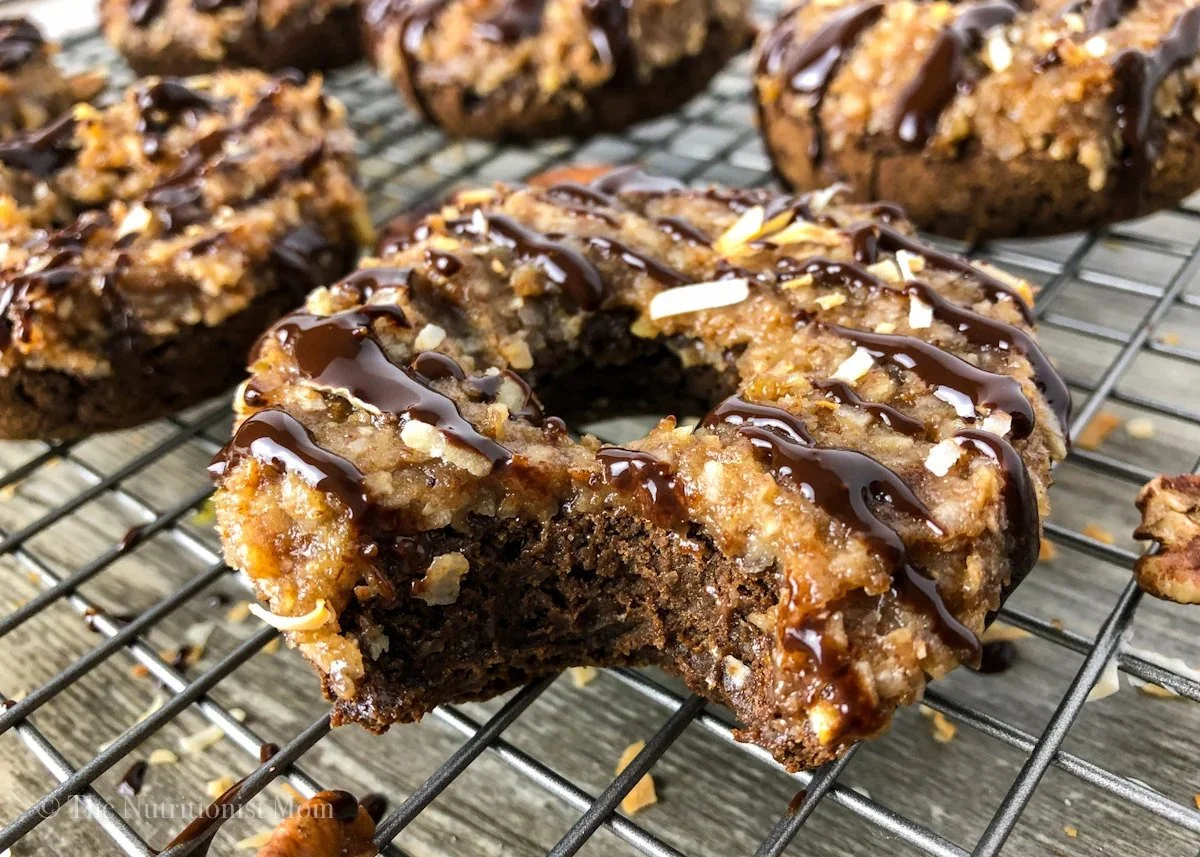 Chocolate chip cookie dough energy bites drizzled with chocolate on cooling rack.