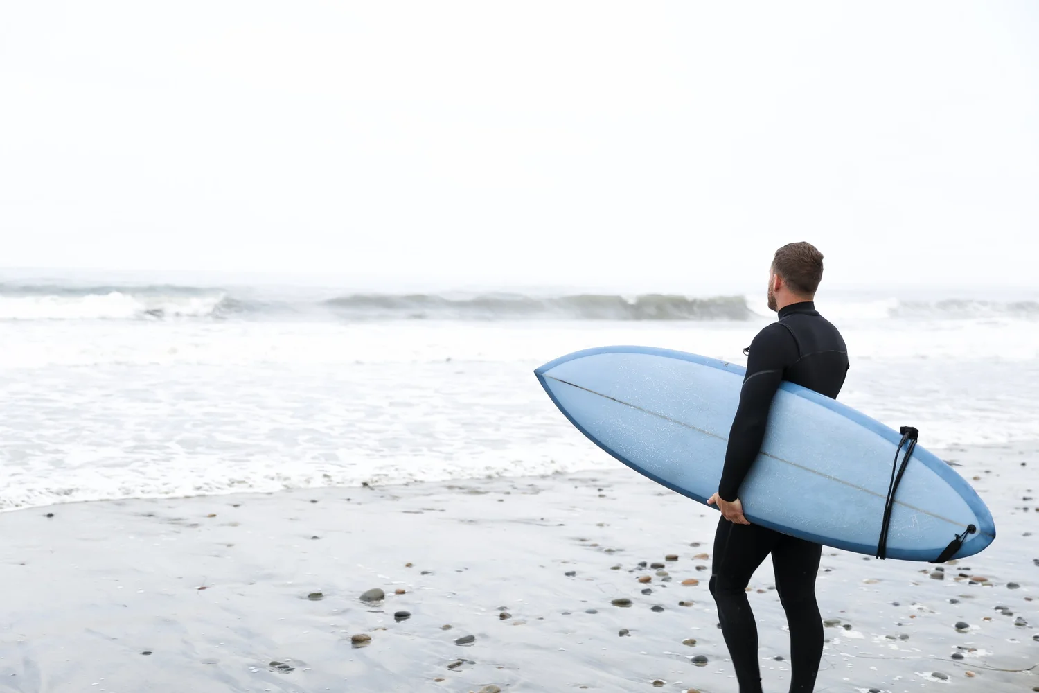 Dr. Yossi Stein, chiropractor at Stein Chiropractic in Clairemont, San Diego, with his surfboard