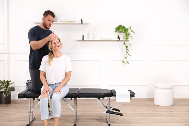 Dr. Yossi Stein evaluating a seated patient at Stein Chiropractic in Clairemont, San Diego