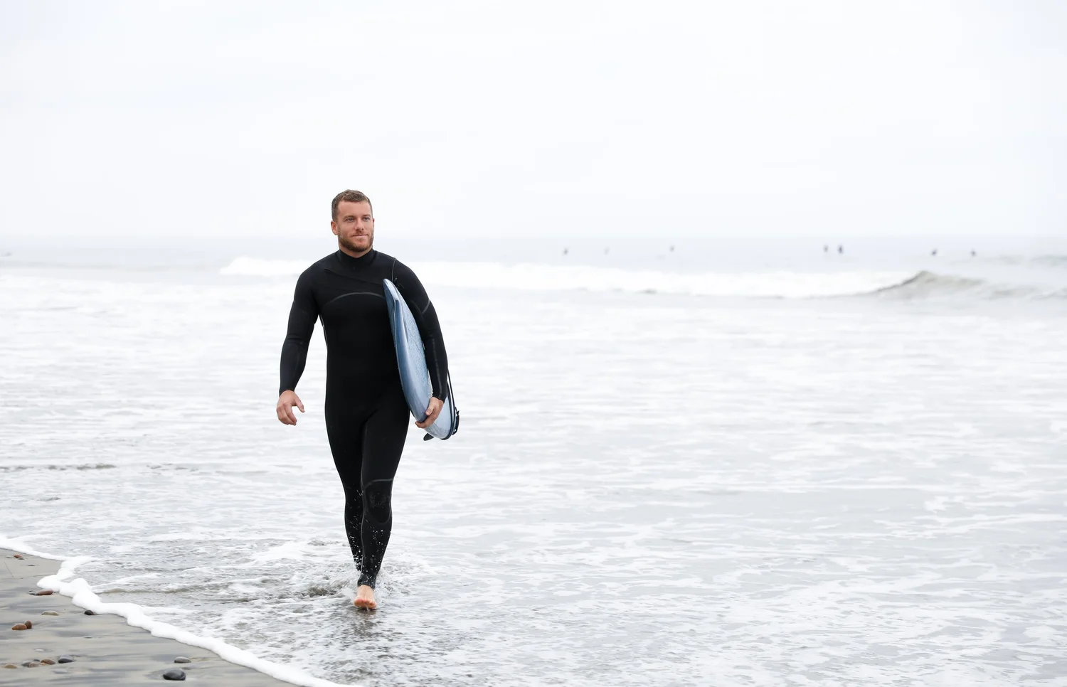 Dr. Yossi Stein at the beach in San Diego wearing a wetsuit