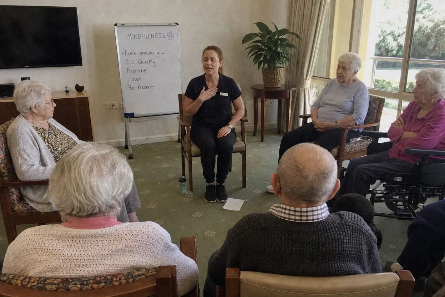 An aged care activity coordinator leading a small seated mindfulness group.