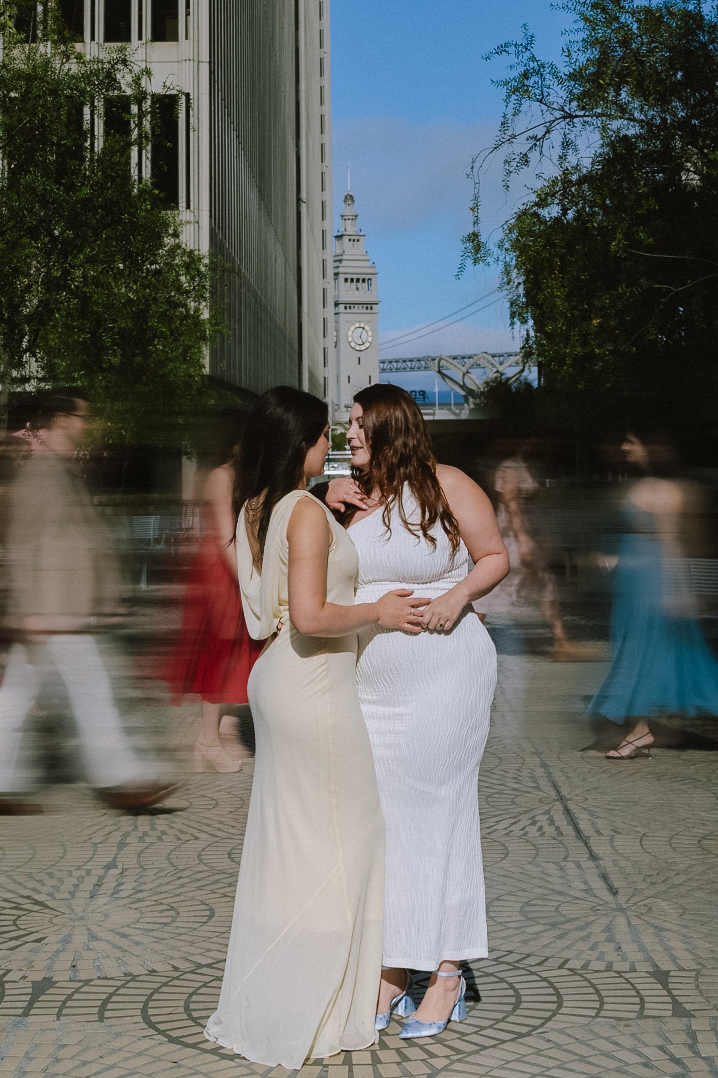 LGBTQ+ couple posing together during a San Francisco engagement session near the Ferry Building, showcasing romantic same sex wedding photography in an urban setting.