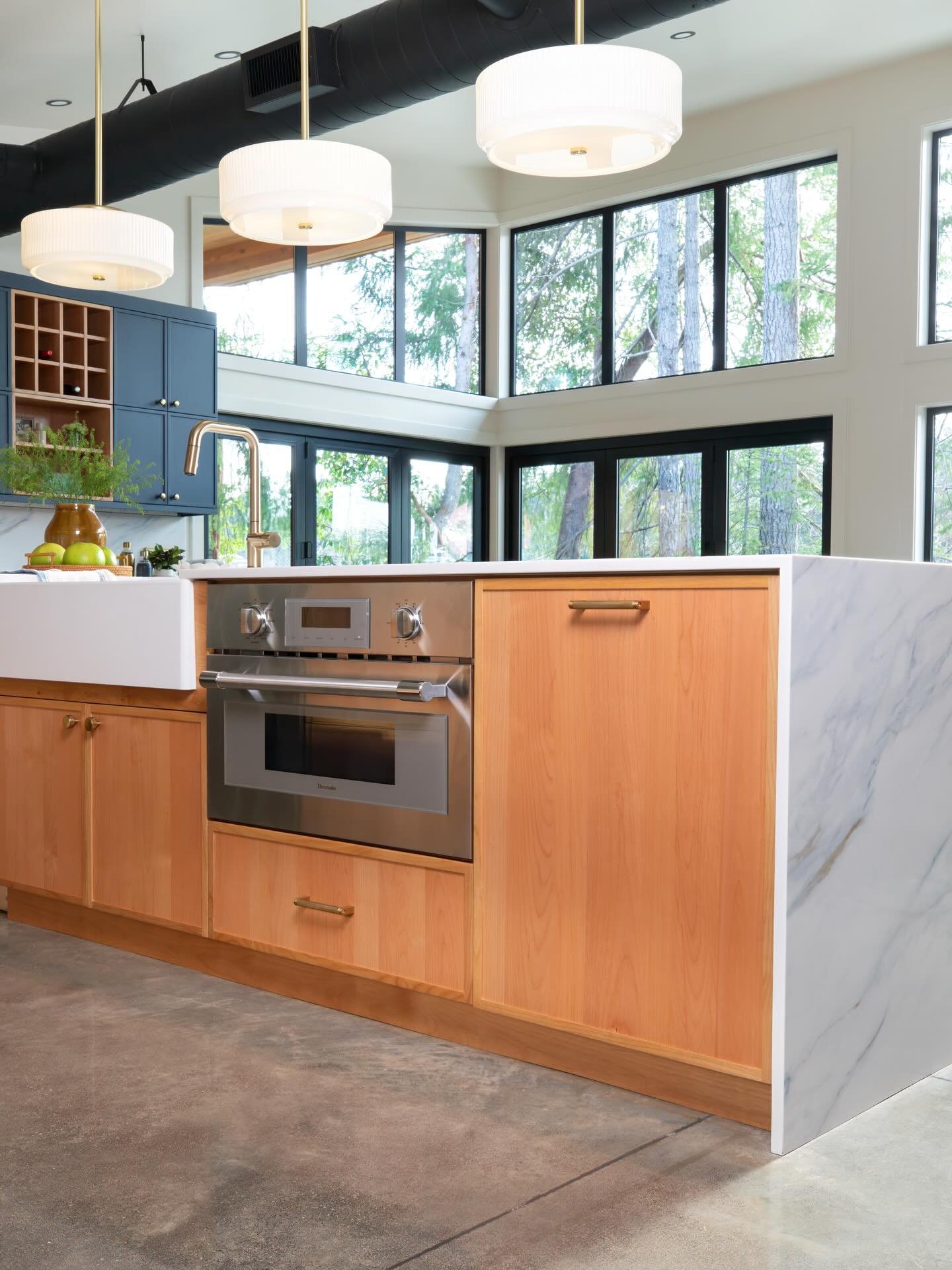 Nestled in the trees and with a front row seat at the lake, we love the way natural materials and tones of the cabinetry bring the outside in. 10/10 would volunteer for dishwashing duty with this view 🧼✨