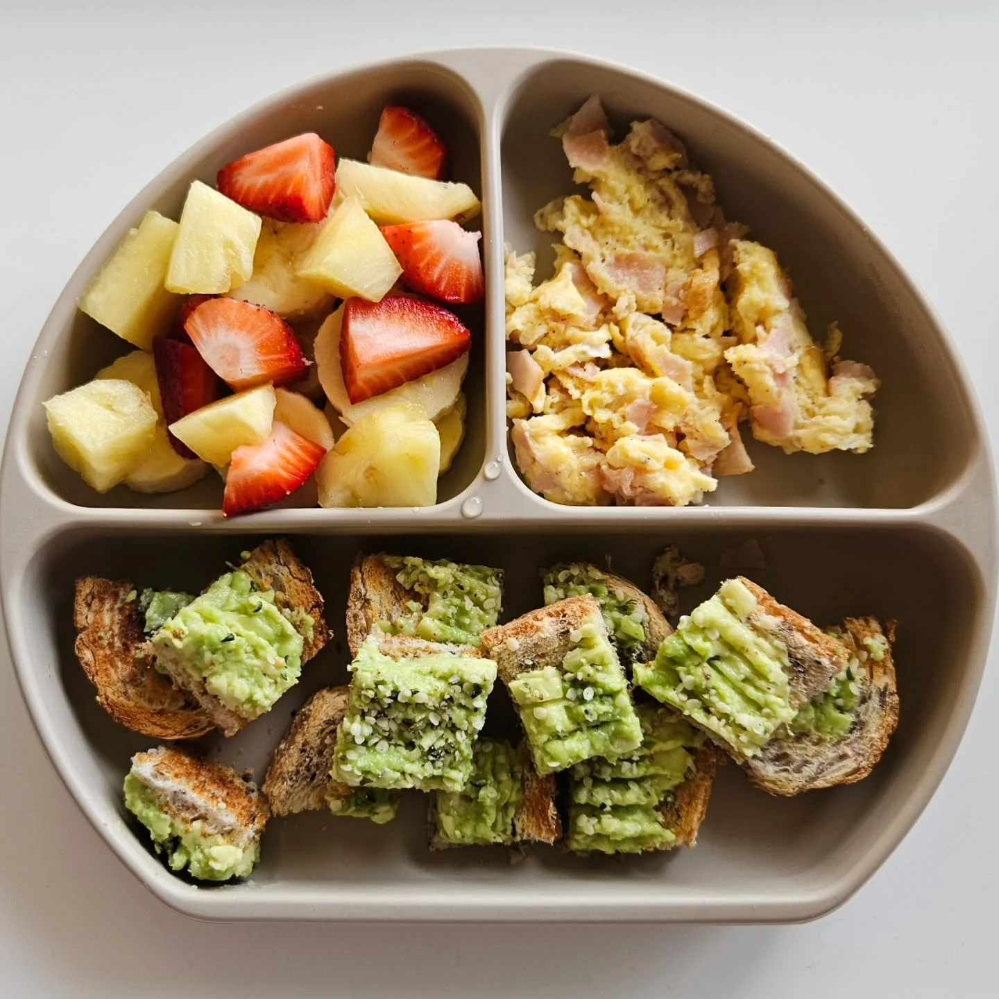 B r e a k f a s t - 18 month old

🌟🌟 EBOOK LINK IN BIO 🌟🌟

◾️ Avocado toast topped with hemp seeds
◾️ Scrambled eggs with ham
◾️ Banana, pineapple &amp; strawberries 

🔅 Plate - @nourishingbubs (gifted)
🔅 Serve - 6m+ (I would recommend omitting