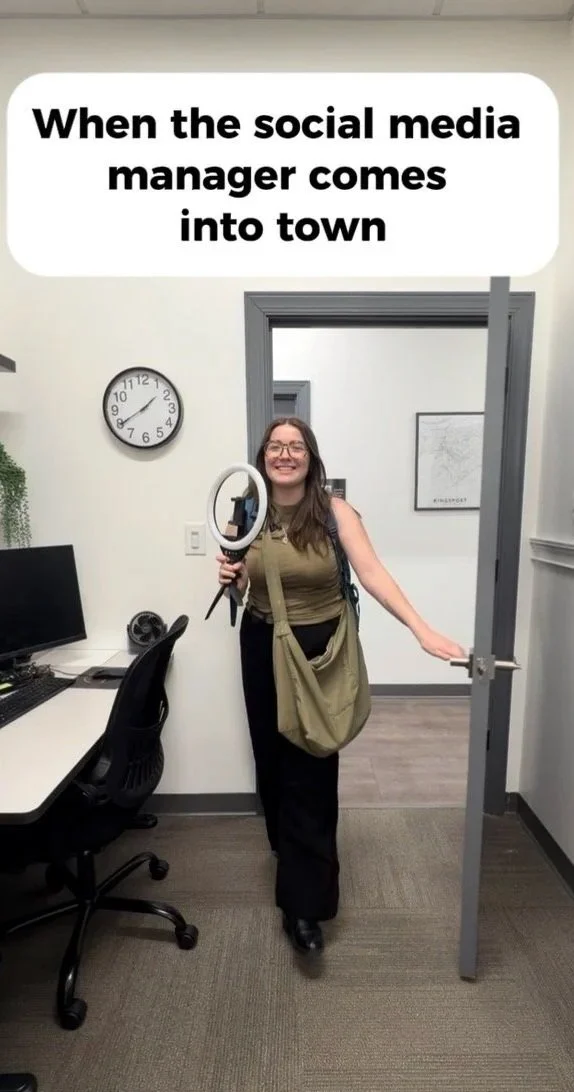 Allie Frye, Ludecker Marr Properties Marketing Director smiling in the doorway of their Real Estate Office excited to film content