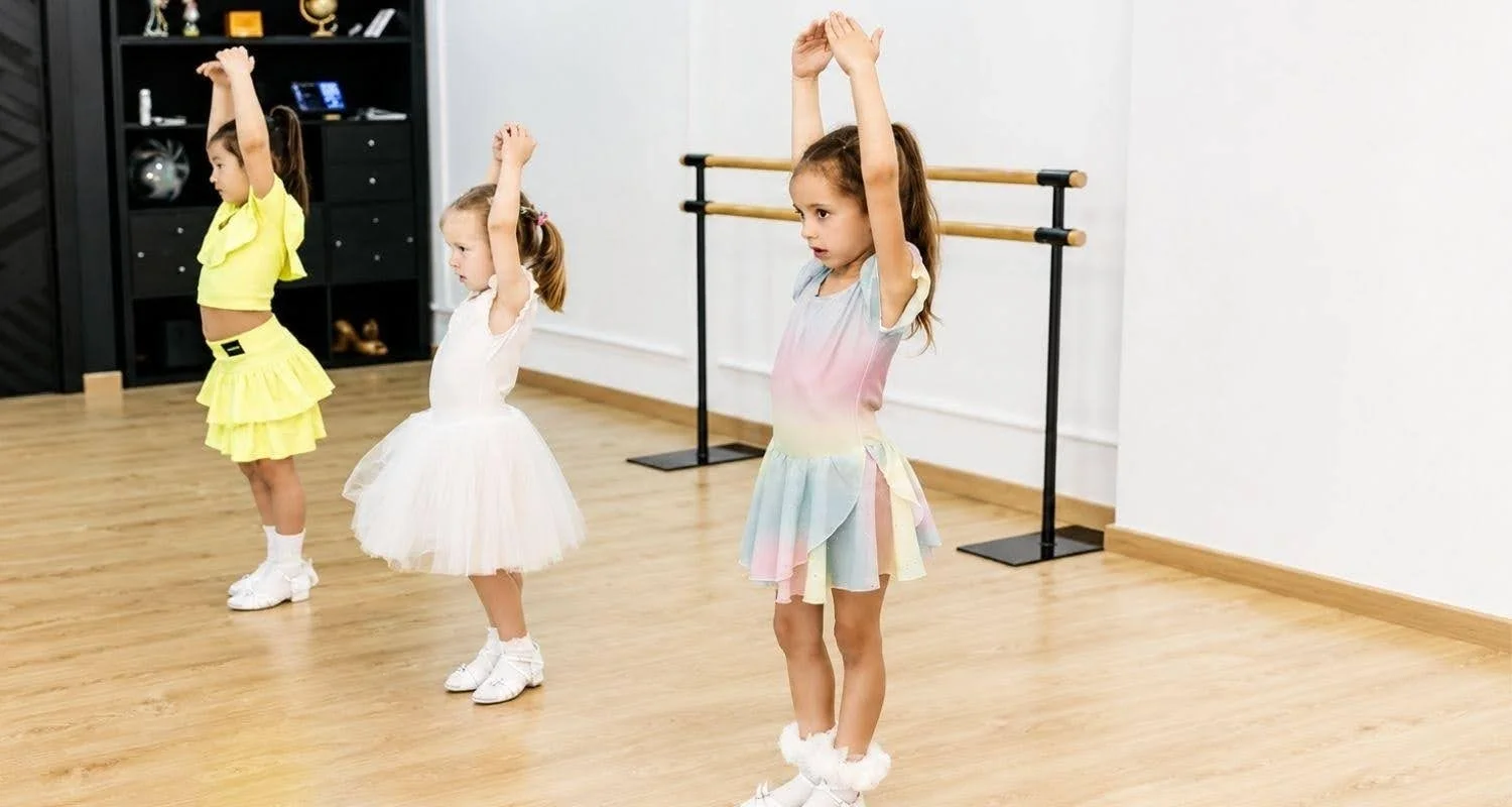 Girls warming up at the barre during dance classes for beginners for kids in Marbella