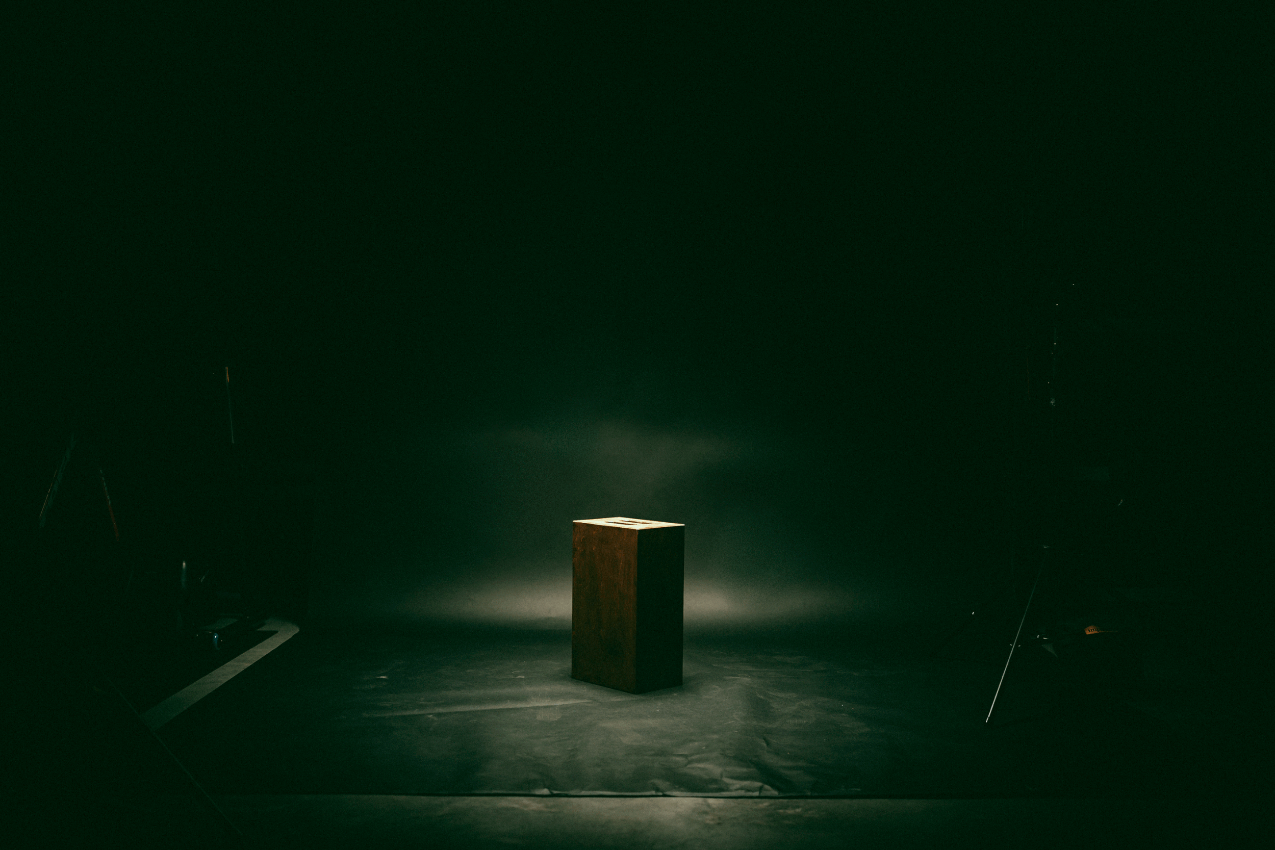 Wooden podium in a dark studio with spotlight.