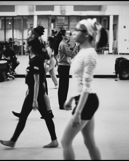 People walking in an airport terminal, with some standing and some moving.