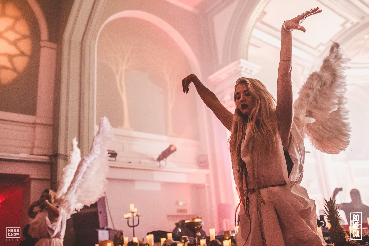 Two female performers in custom angel wings dance at Boneca, a luxury immersive party at One Marylebone, London. Performers, costume and choreography by Secret Productions.