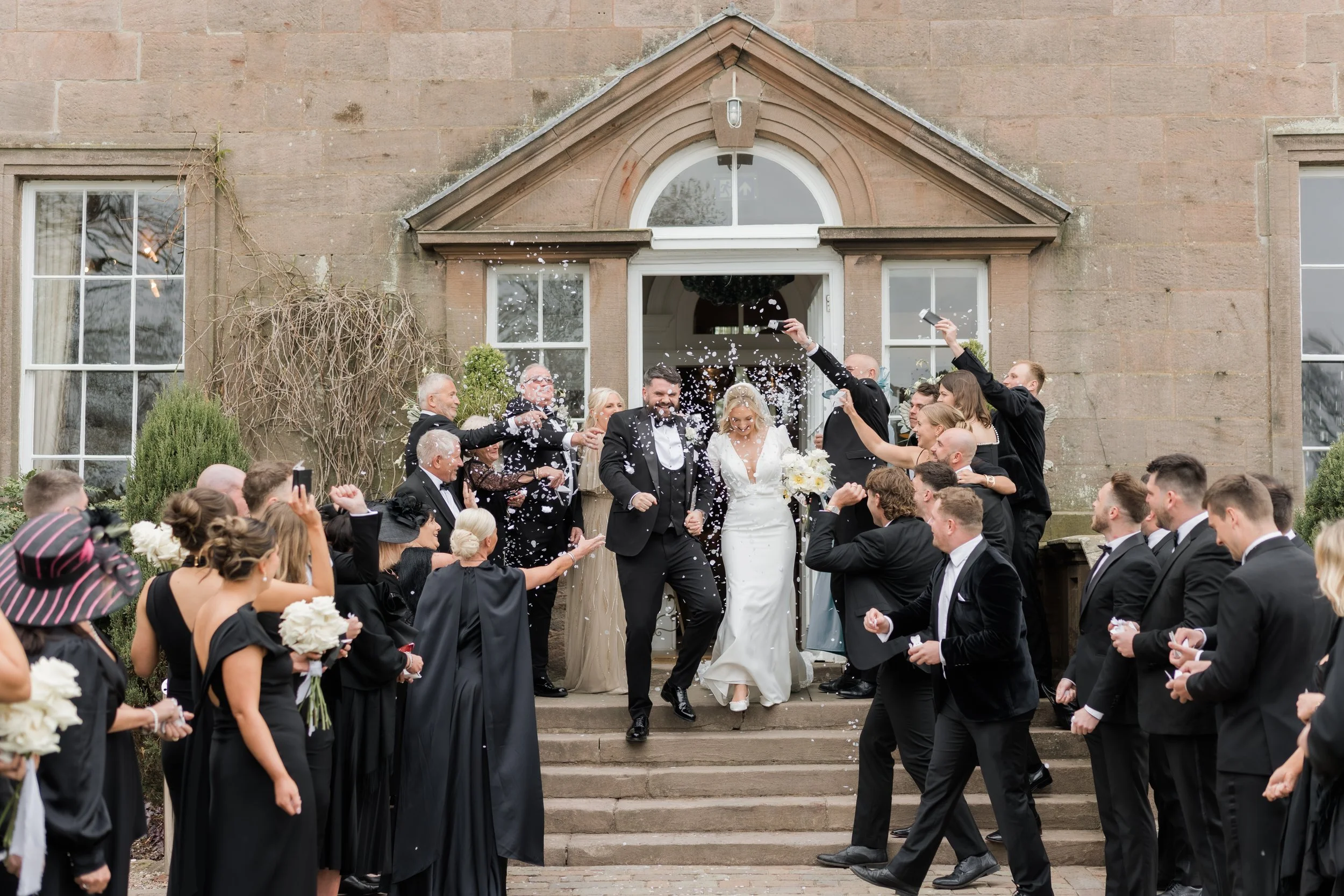 Just married moment as the couple walk through confetti at Charlton Hall, captured with natural joy and movement