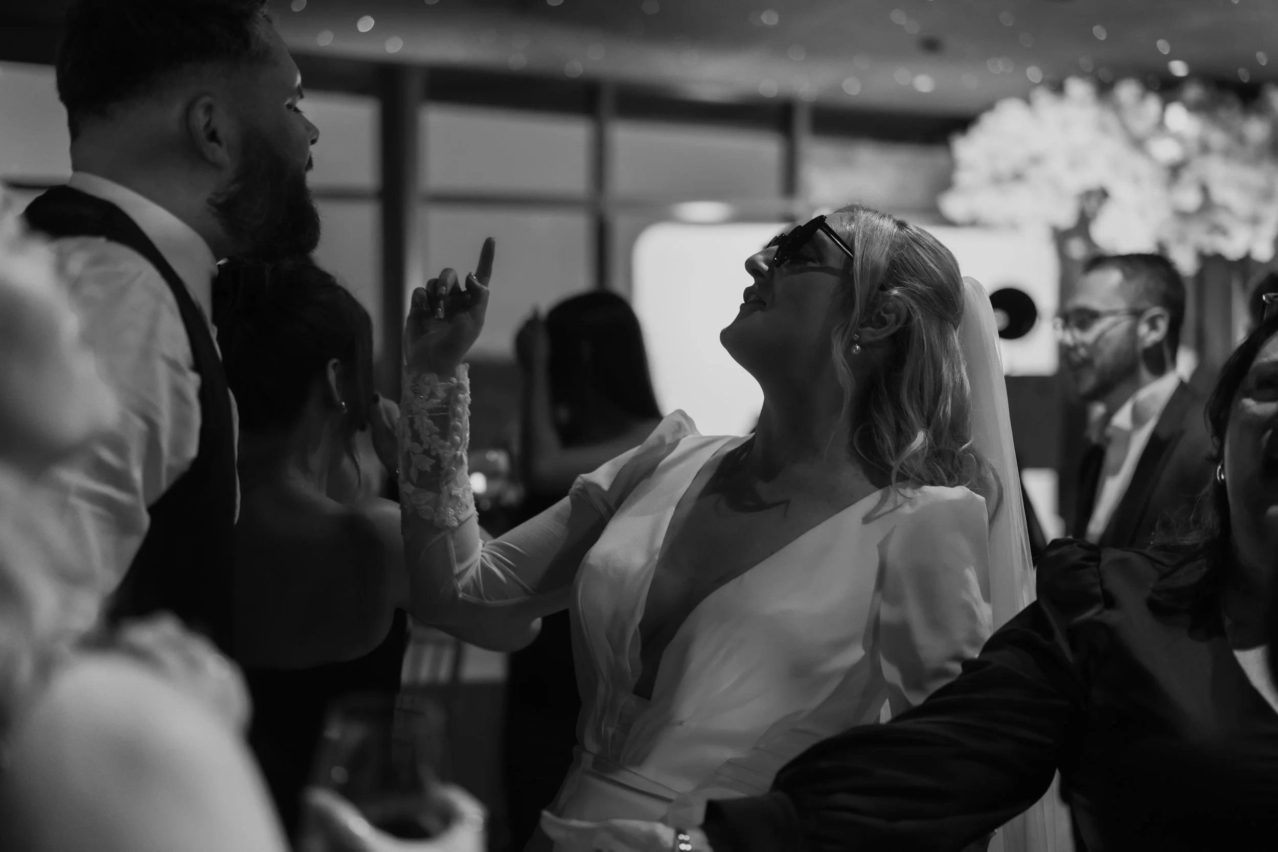 A bride and a man are engaged in a heated exchange at a wedding reception, with the bride raising her finger toward the man.