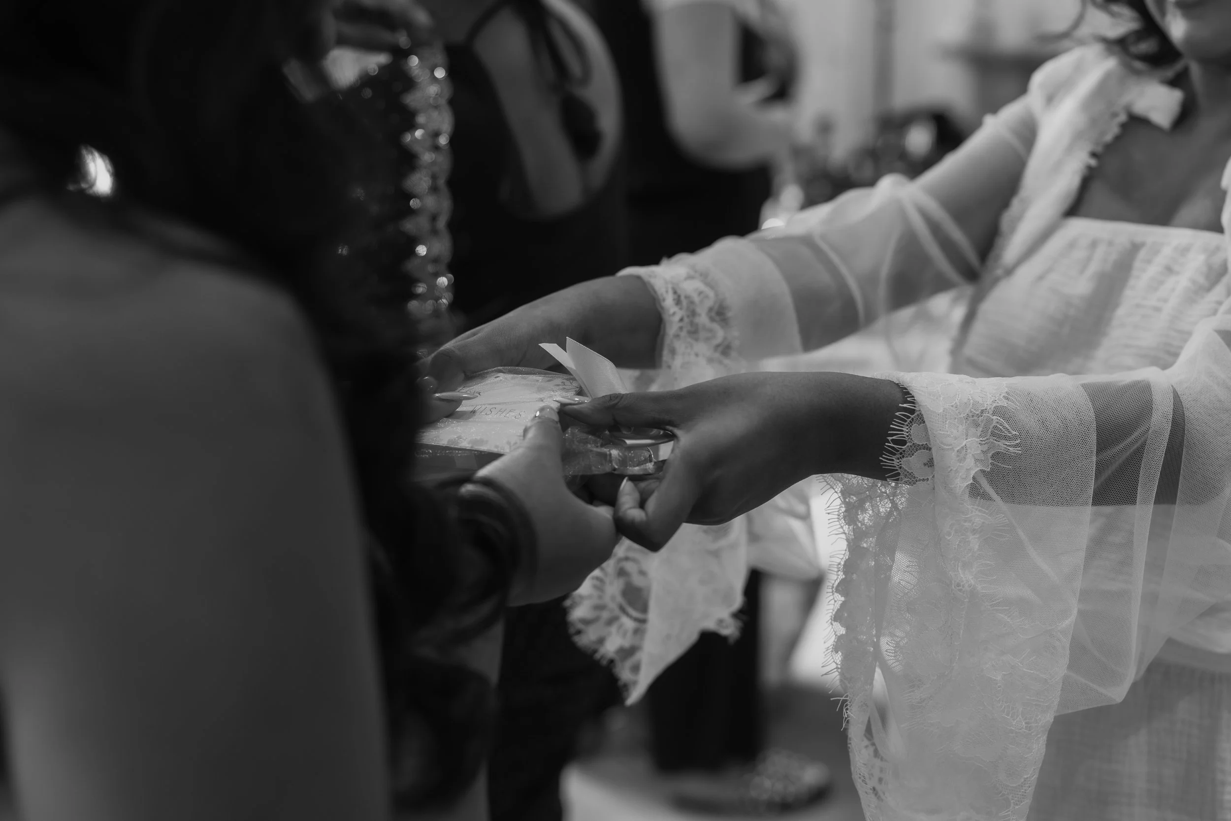 Two women exchanging a gift in a heartfelt moment, with one woman wearing lace cuffs on her sleeves.