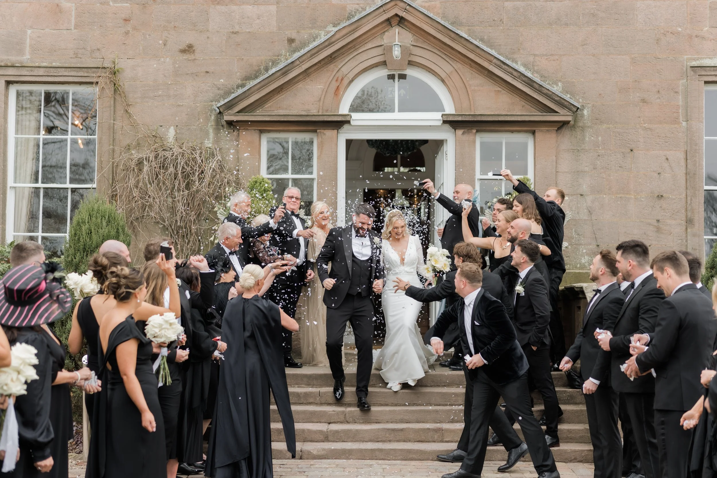 Just married moment as the couple walk through confetti at Charlton Hall, captured with natural joy and movement