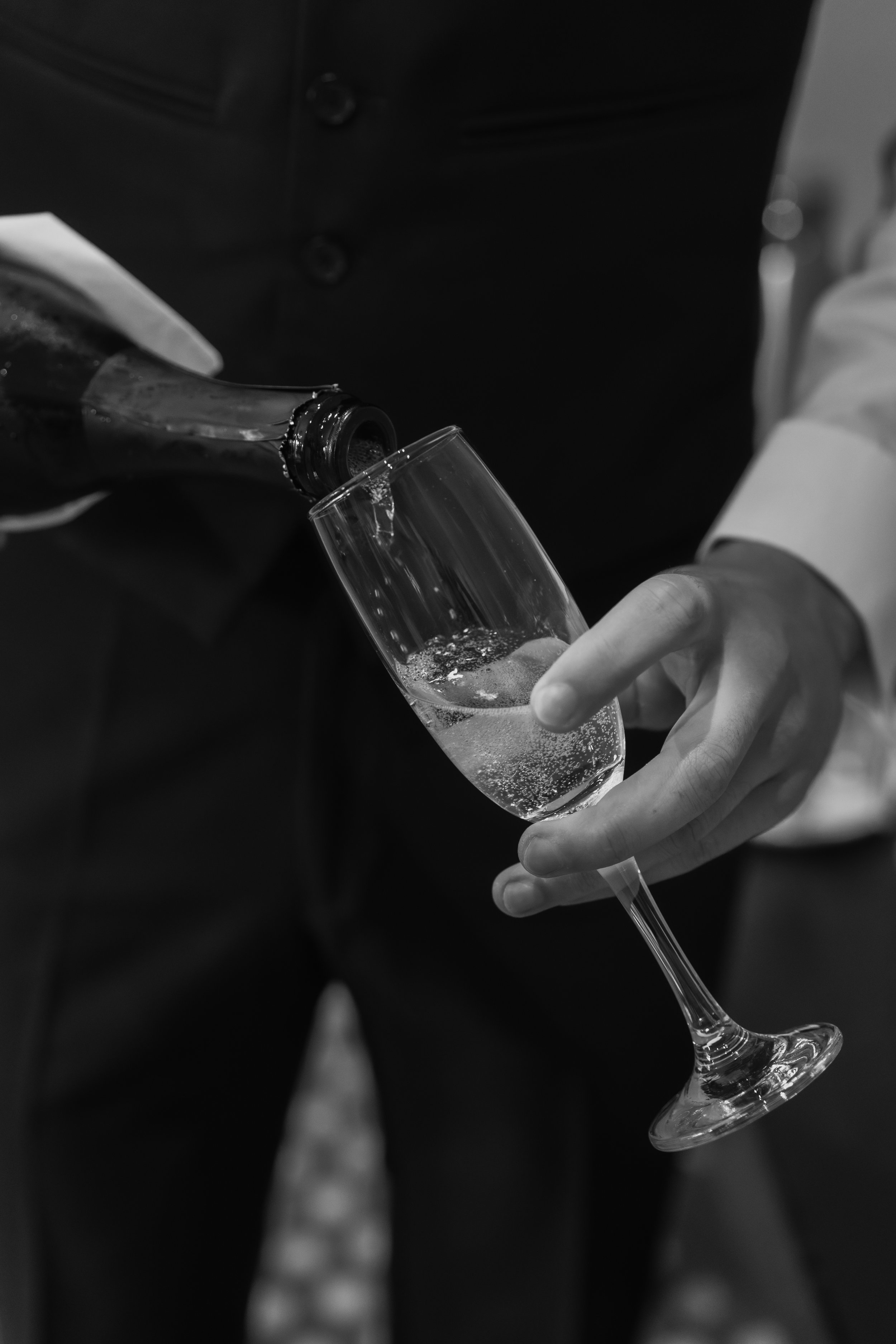 A person pouring champagne into a flute glass.
