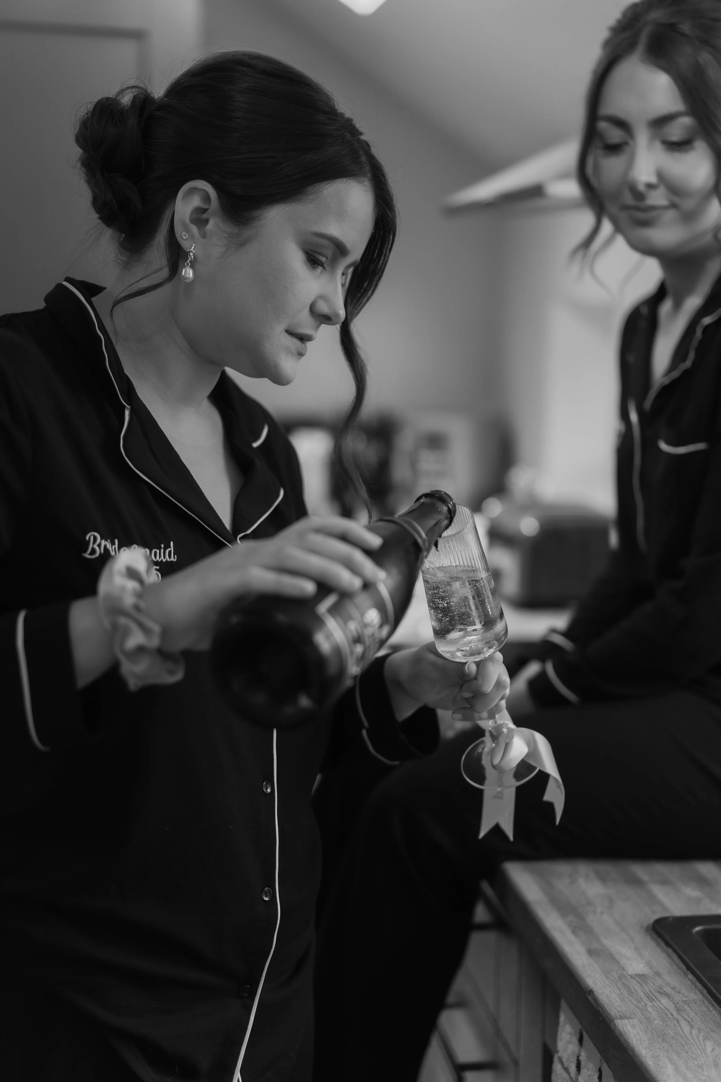 Bridesmaids pour champagne black and white documentary