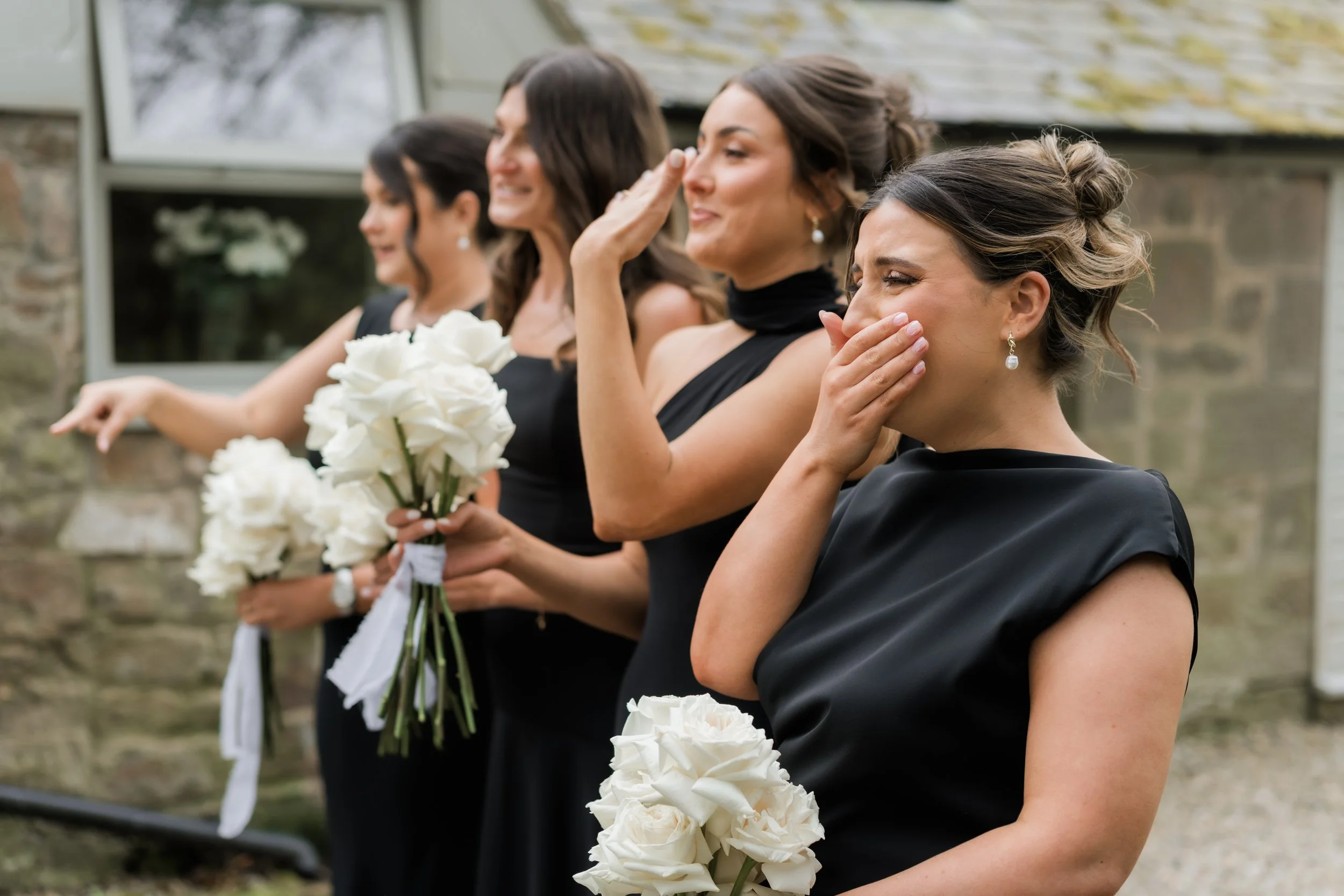 Candid reactions as bridesmaids see the bride for the first time, captured in a natural, elegant style