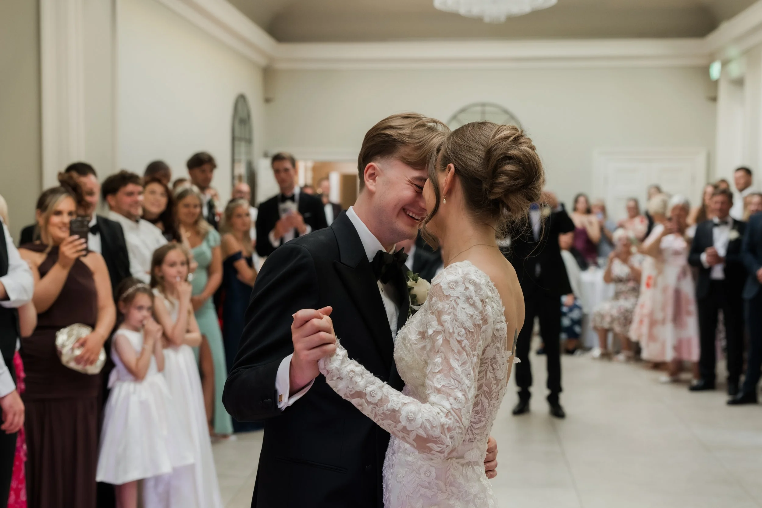 Groom smiles and touches forhead to brides during first dance