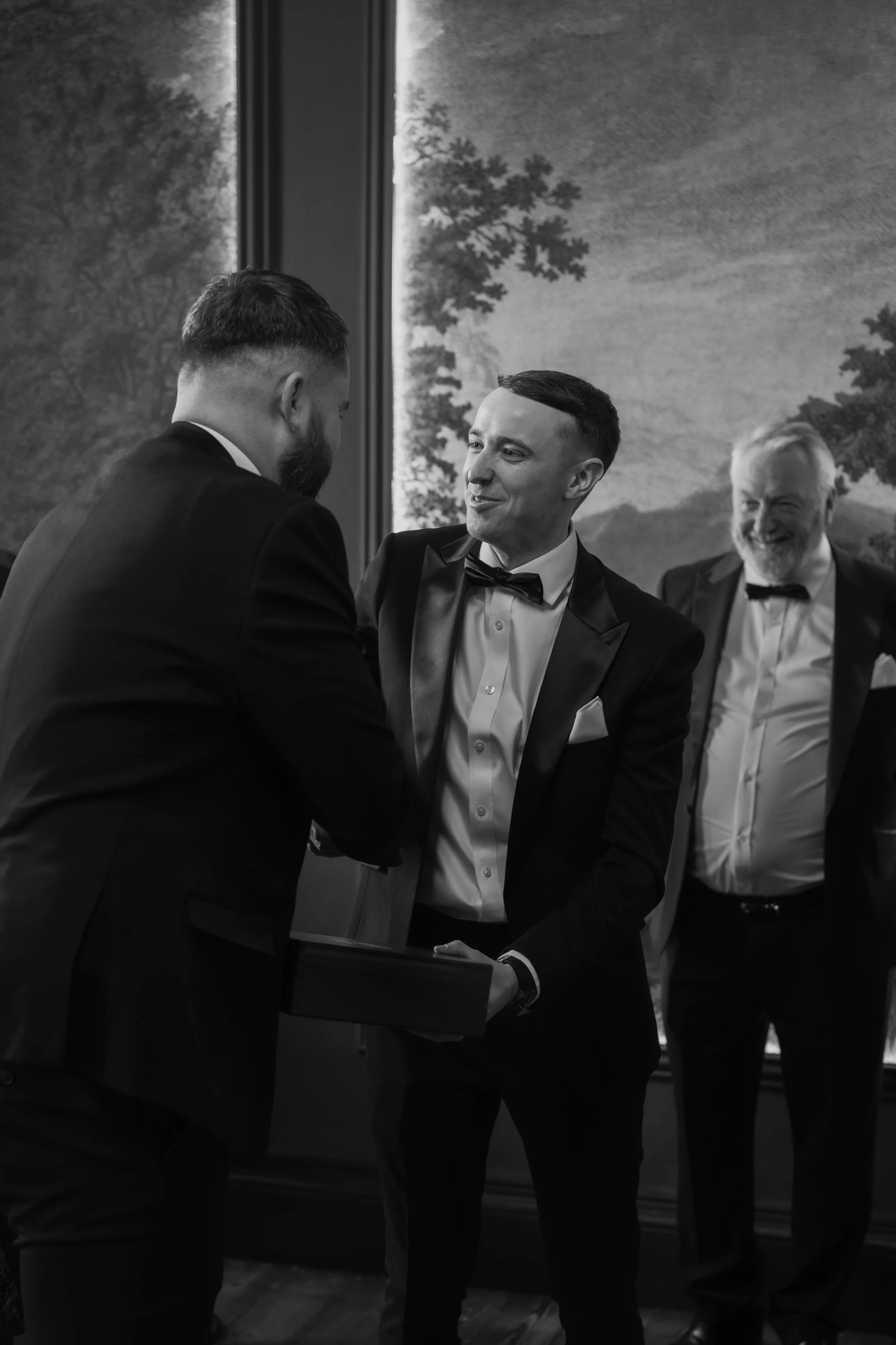 Groom giving personalised gifts to his groomsmen, captured in a natural, documentary style
