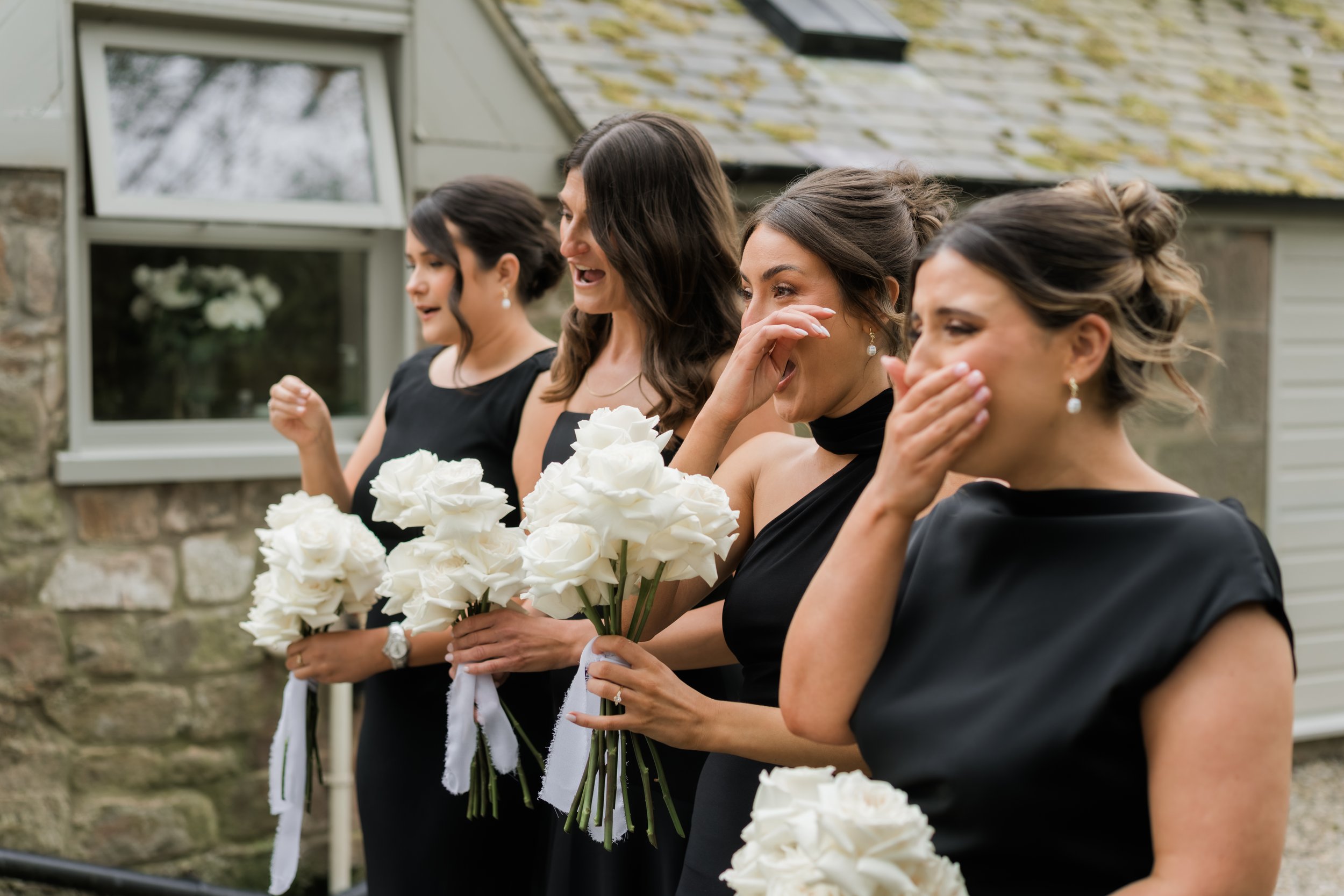 Black-tie bridal party sharing a joyful first look moment at Charlton Hall