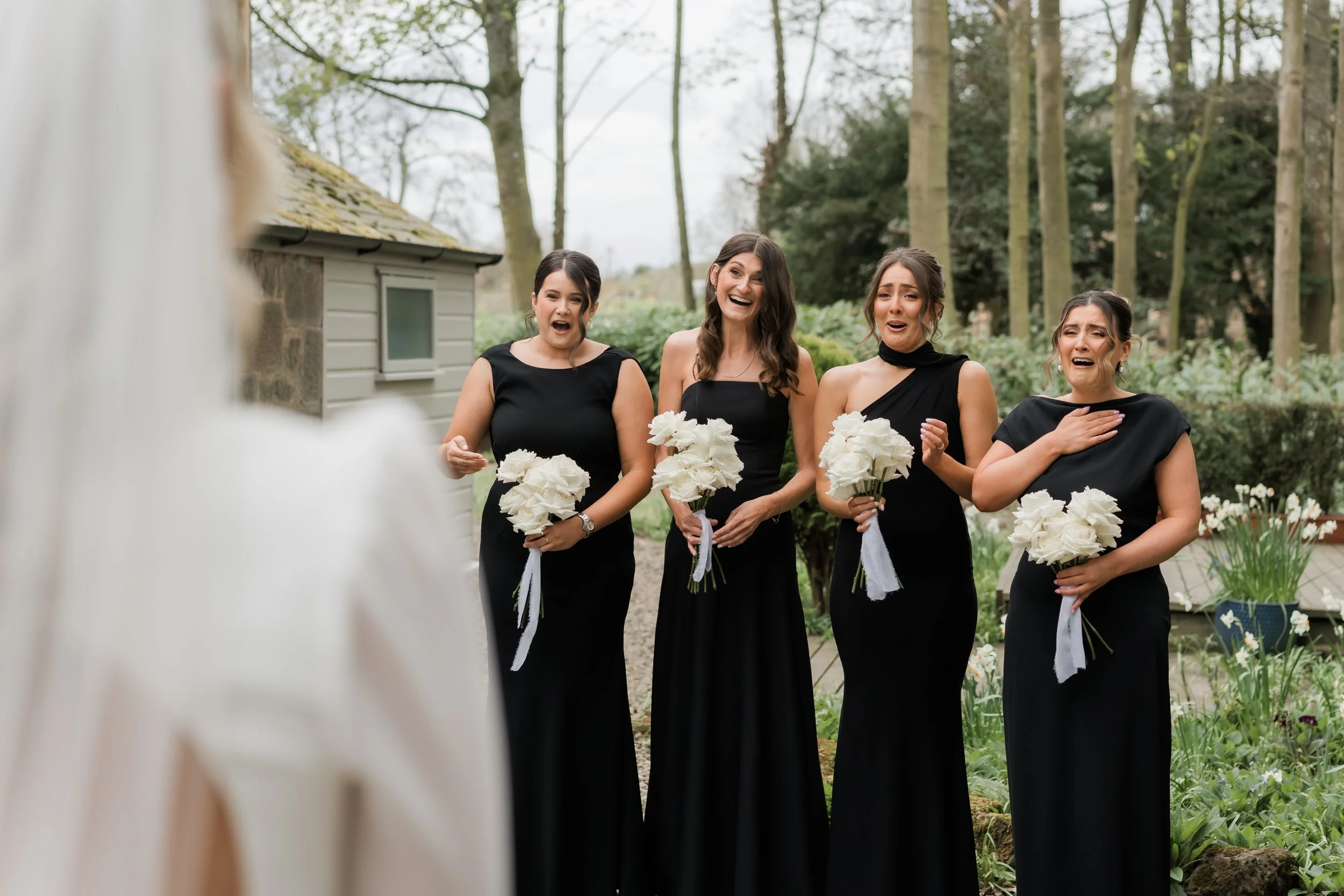 Emotional first look with the bride and bridesmaids in black-tie attire at Charlton Hall
