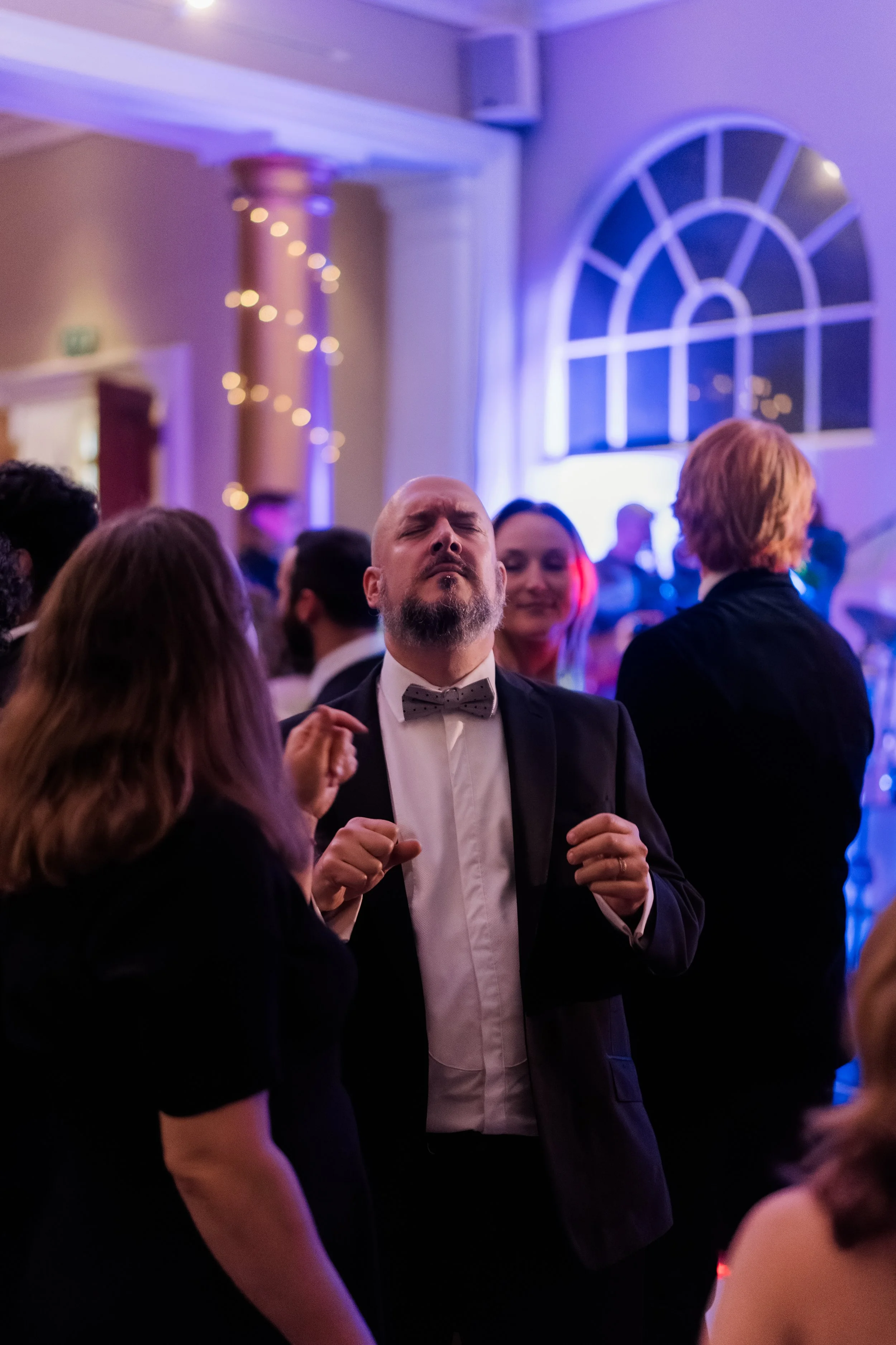 Wedding guest dancing lit by neon DJ lighting no flash Rudding Park