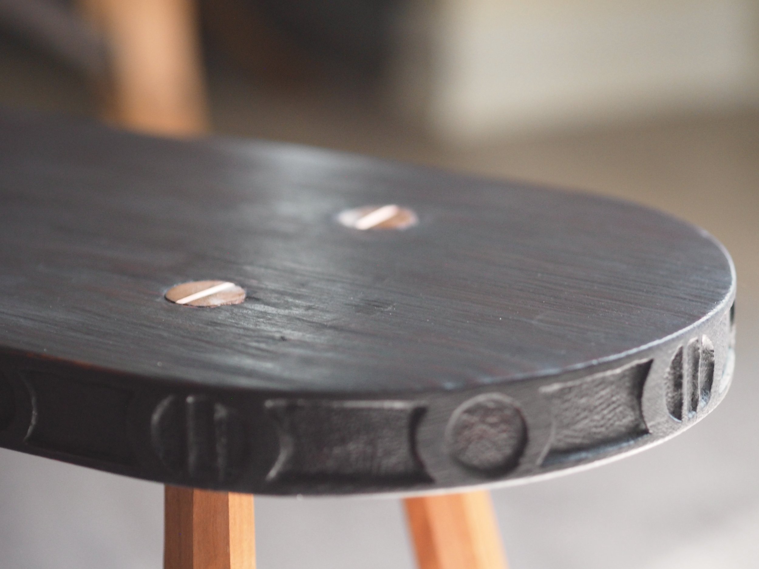 Ebonized wood cherry bench coffee table with hand carved edge pattern and copper inlay