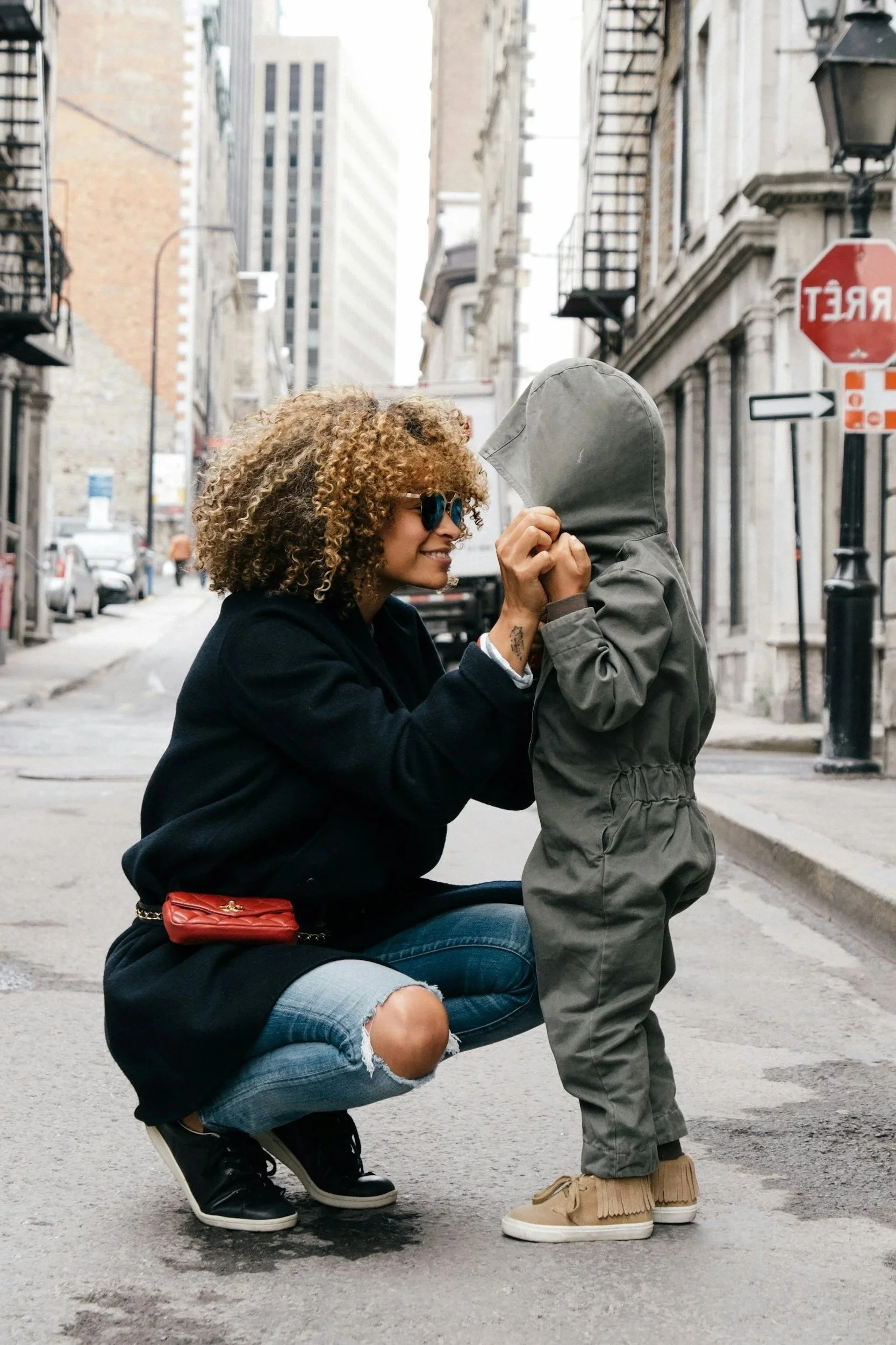 African American Black mother kneeling and talking to child  