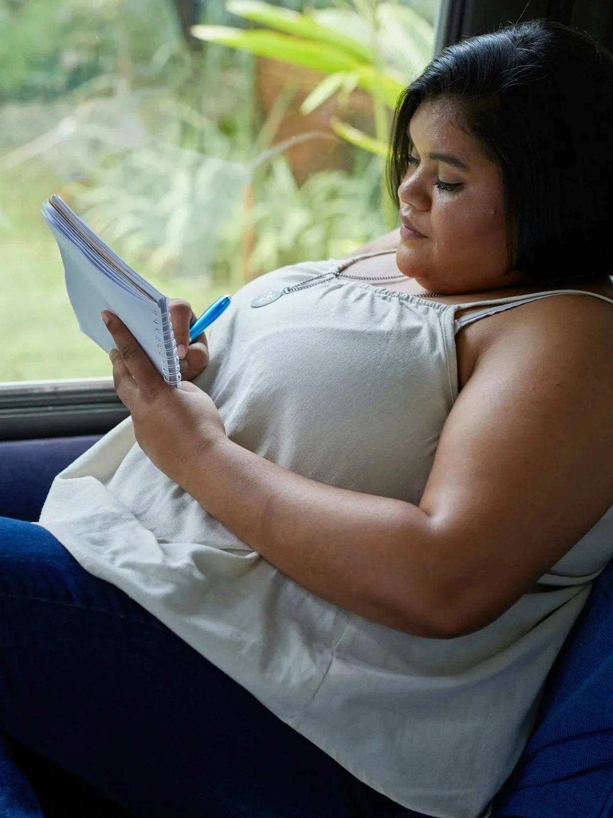 pregnant  Latina mother journaling