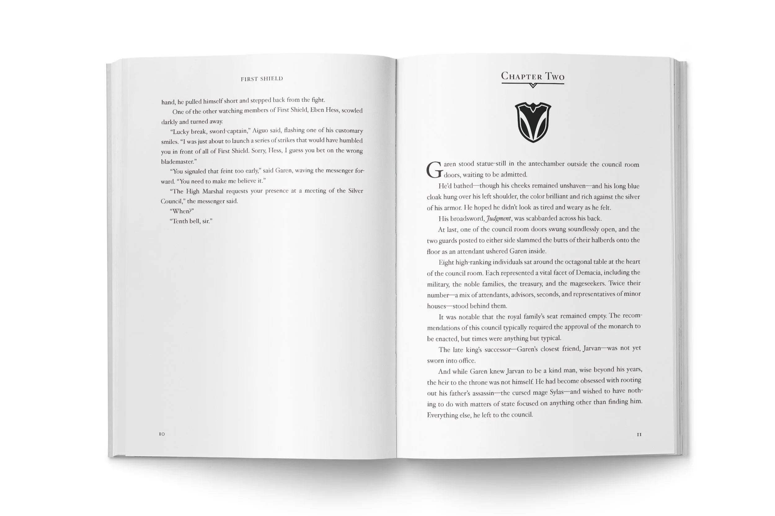 An open paperback book showing pages 10 and 11 of Garen First Shield. The text is black on white paper. The left page says "First Shield" at the top. The right page is the first page of chapter two
