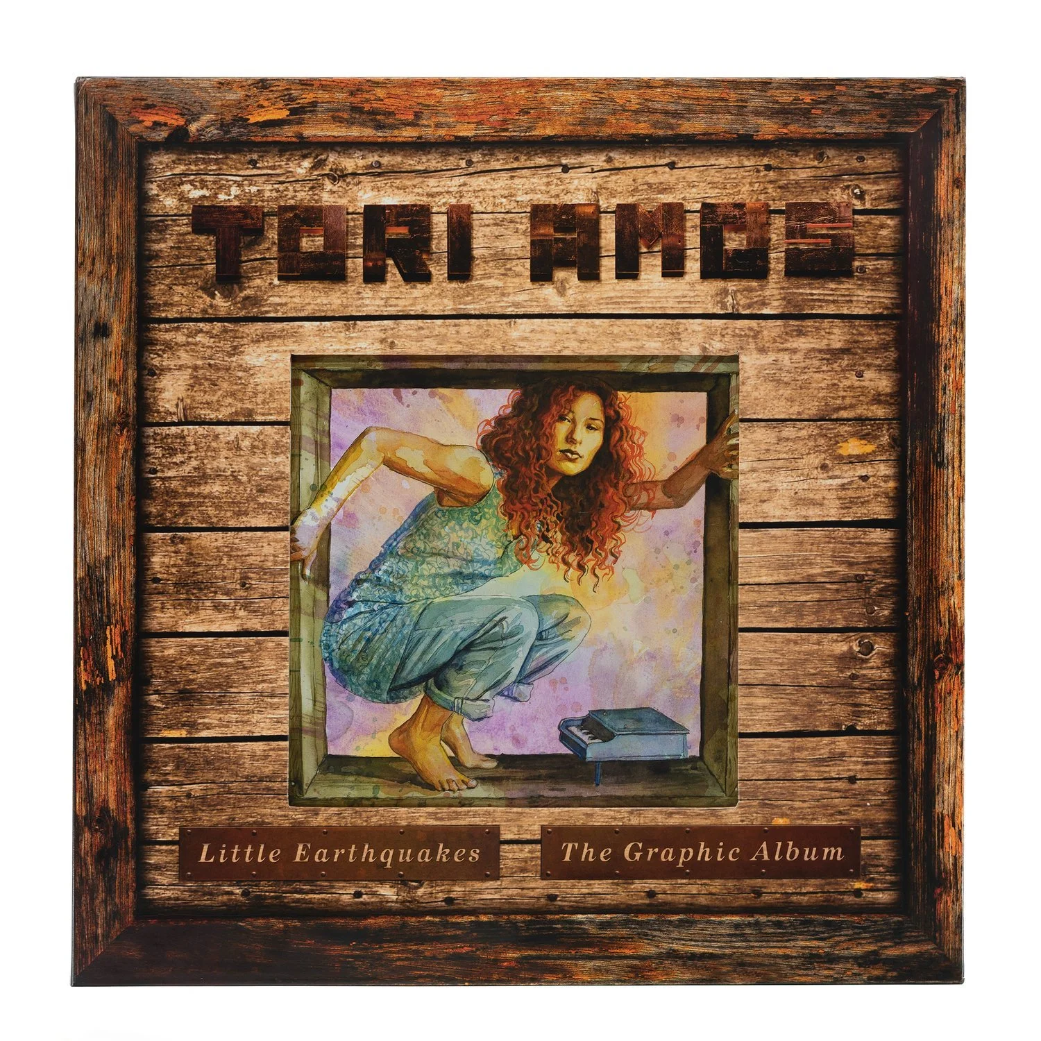 A wood box with the name "TORI AMOS" in letters made of wood. Below that is a watercolor by David Mack of Tori crouched in a wood box. She's wearing blue and is crouched over a tiny piano. Below that it reads "Little Earthquakes The Graphic Album"