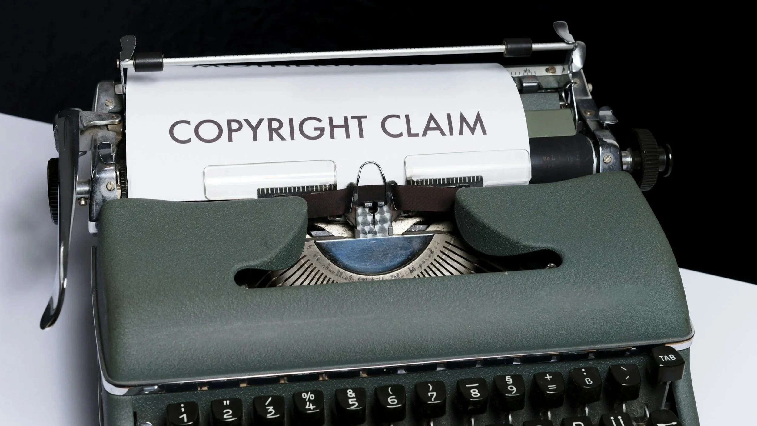 Oldschool typesetting machine showing "copyright Claim" in bold text typed on the paper