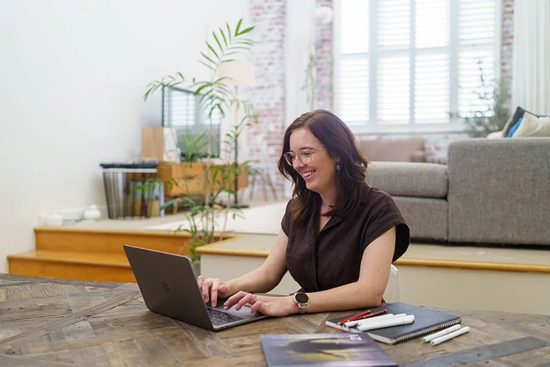 a woman sitting at a laptop in a modern living room