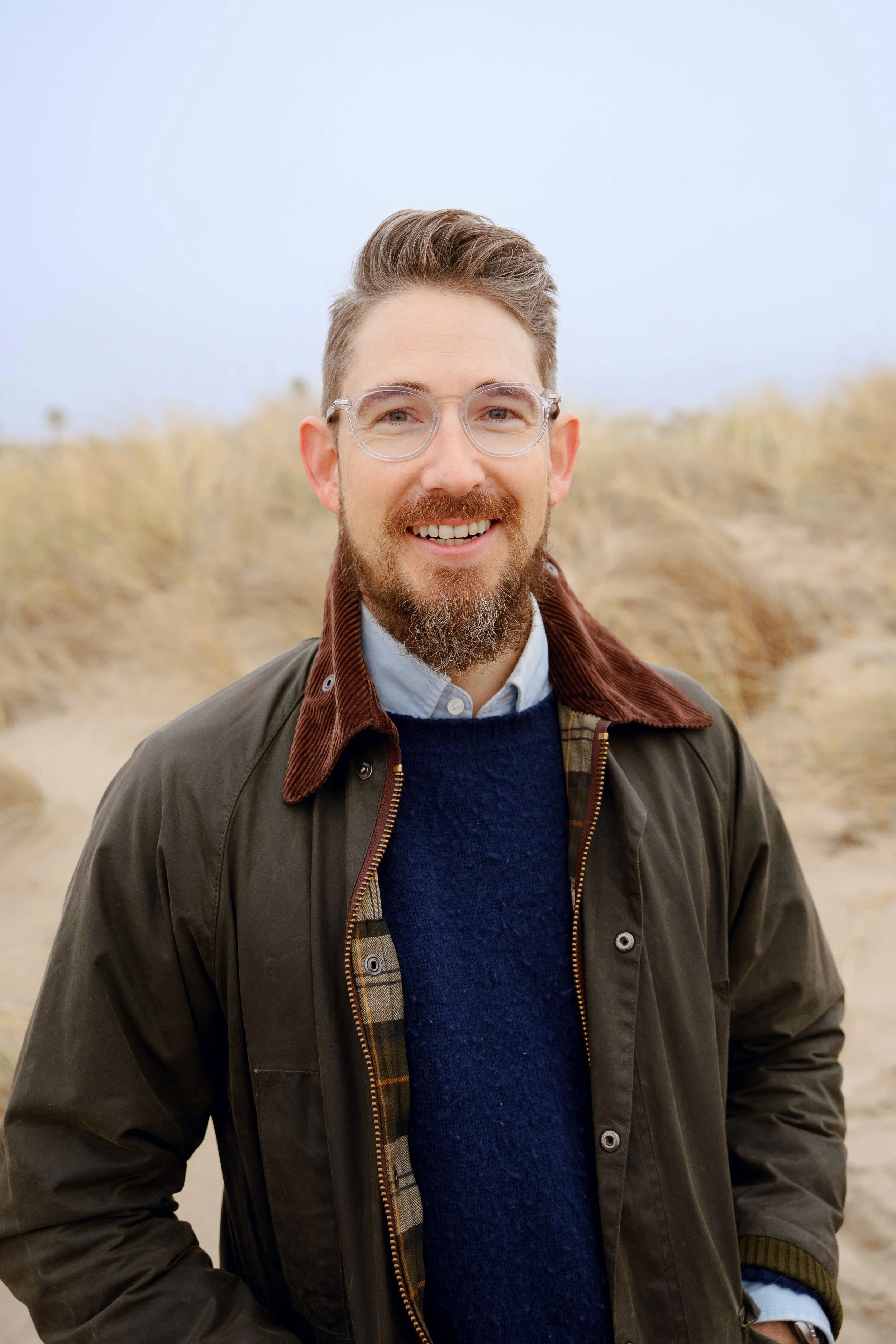Portrait of Matt Hall standing outdoors, smiling confidently and warmly.