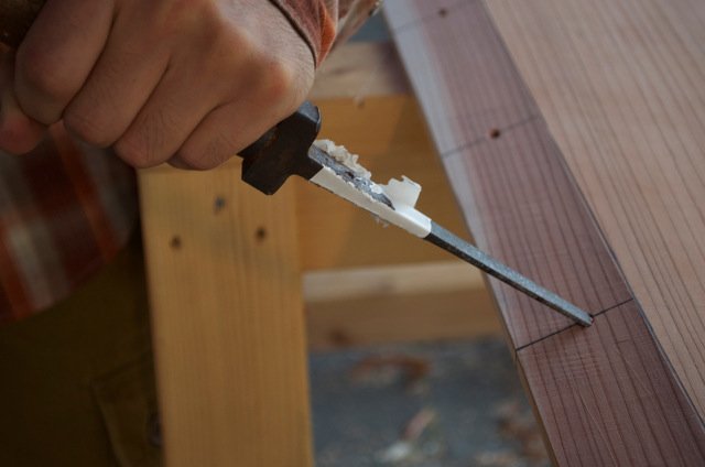Using the tsubanomi, a special chisel for piloting nail holes.