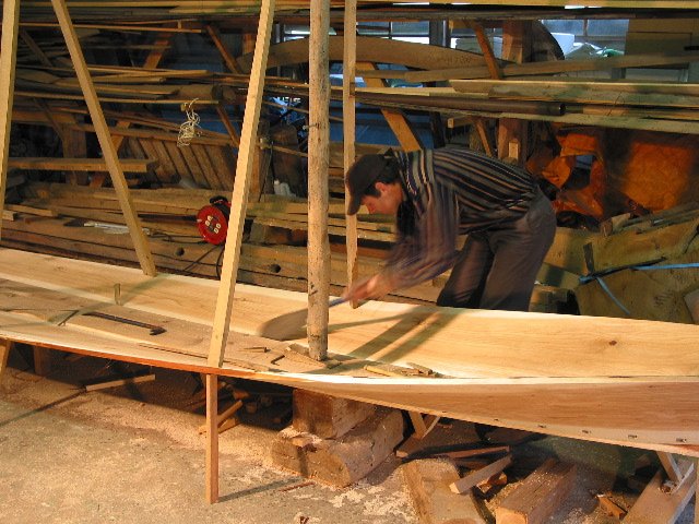Saw fitting the seam between the first plank and the keel.