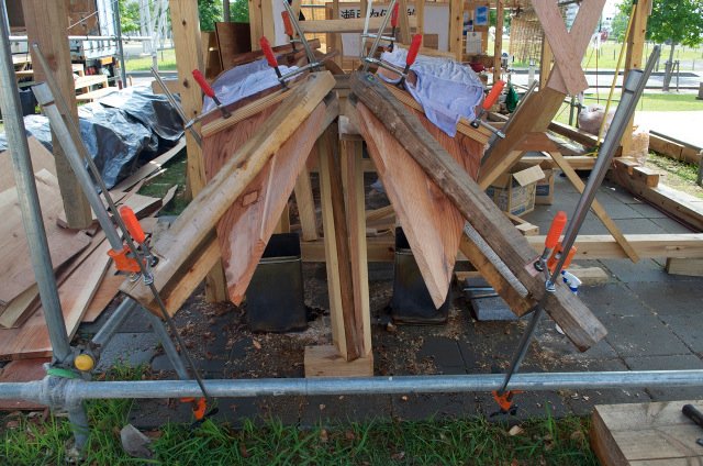Bending the garboard planks (kajiki) over wood fire. Japanese boatbuilders pre-bend their planks off the boat.