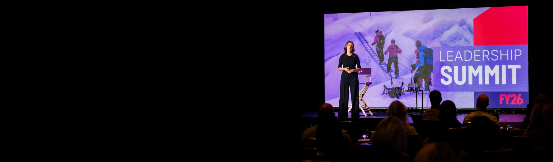 Professional keynote speaker on stage with LED wall backdrop at a corporate event in Utah