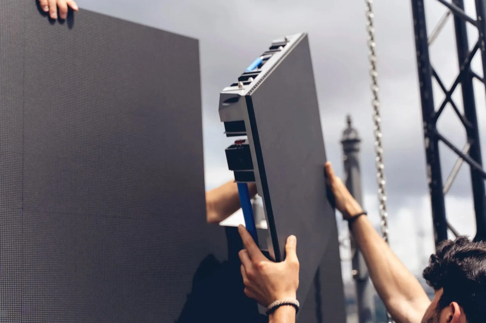 Technician assembling modular LED wall panels during event setup