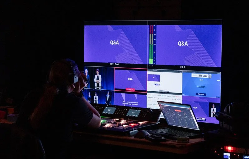 Backstage graphics technician viewing a multiview feed during a corporate event
