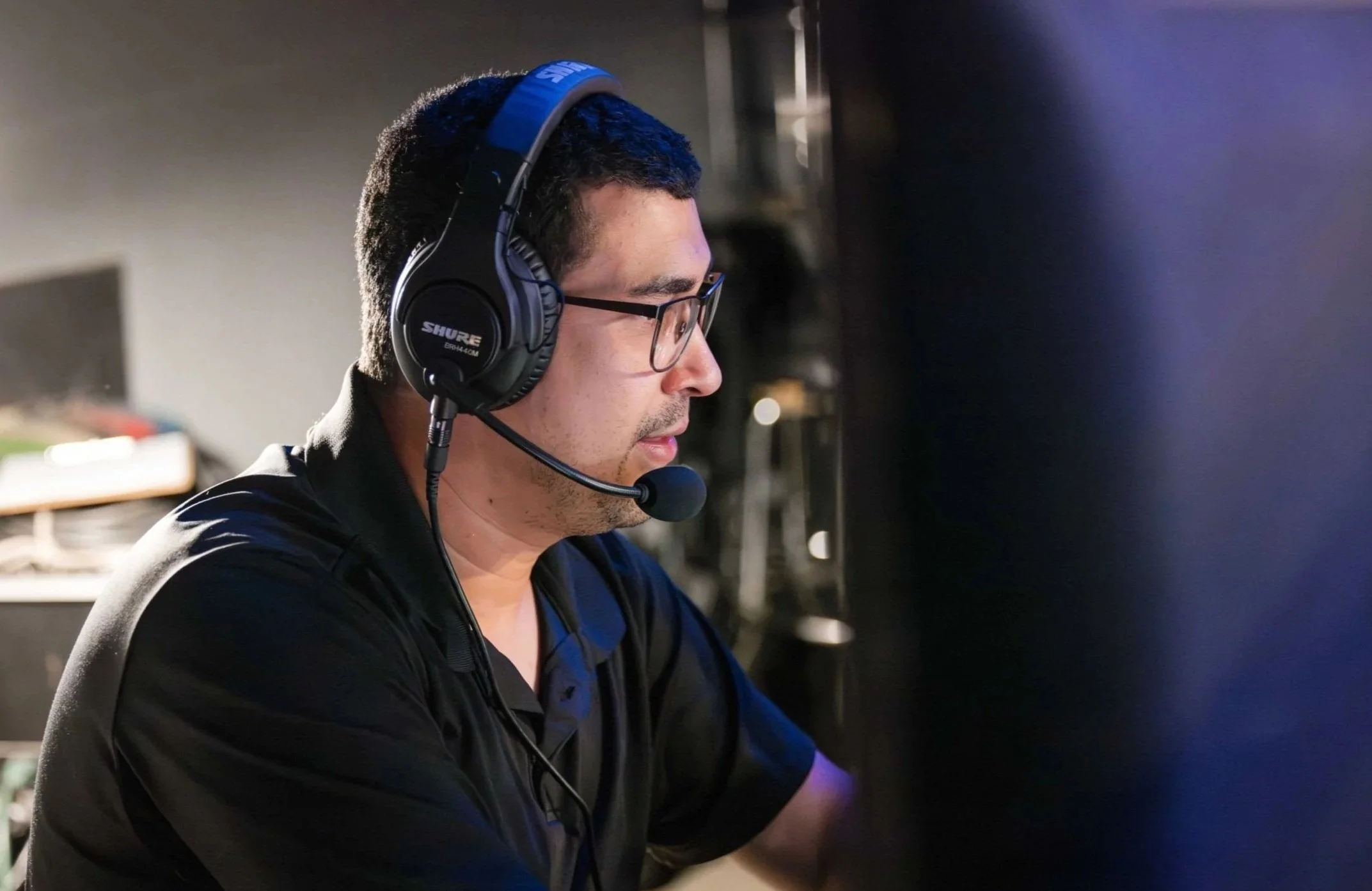 Show caller wearing headset and monitoring cues from backstage computer