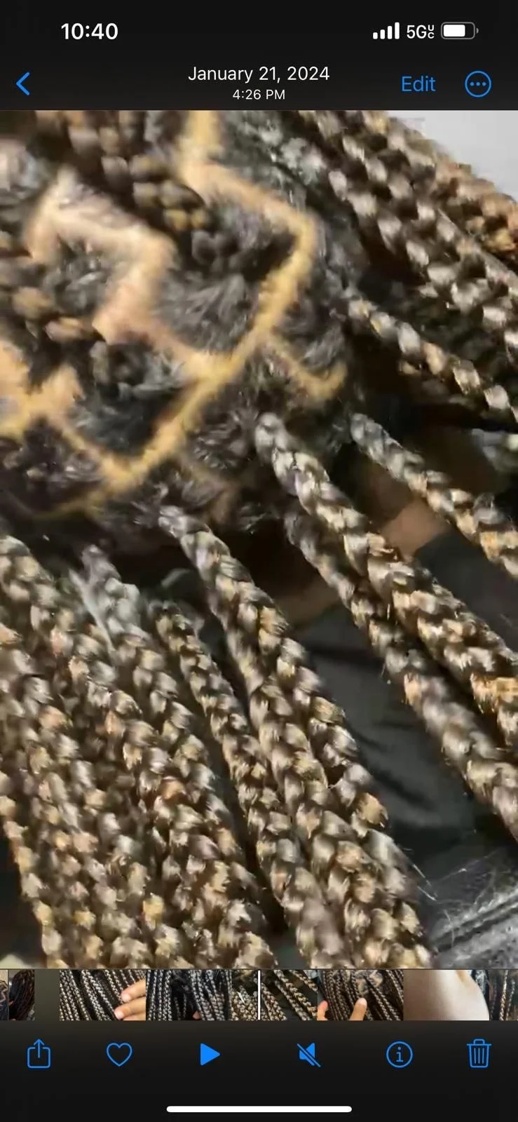 Close-up of tightly braided, multicolored synthetic hair extensions in shades of brown, blonde, and black.
